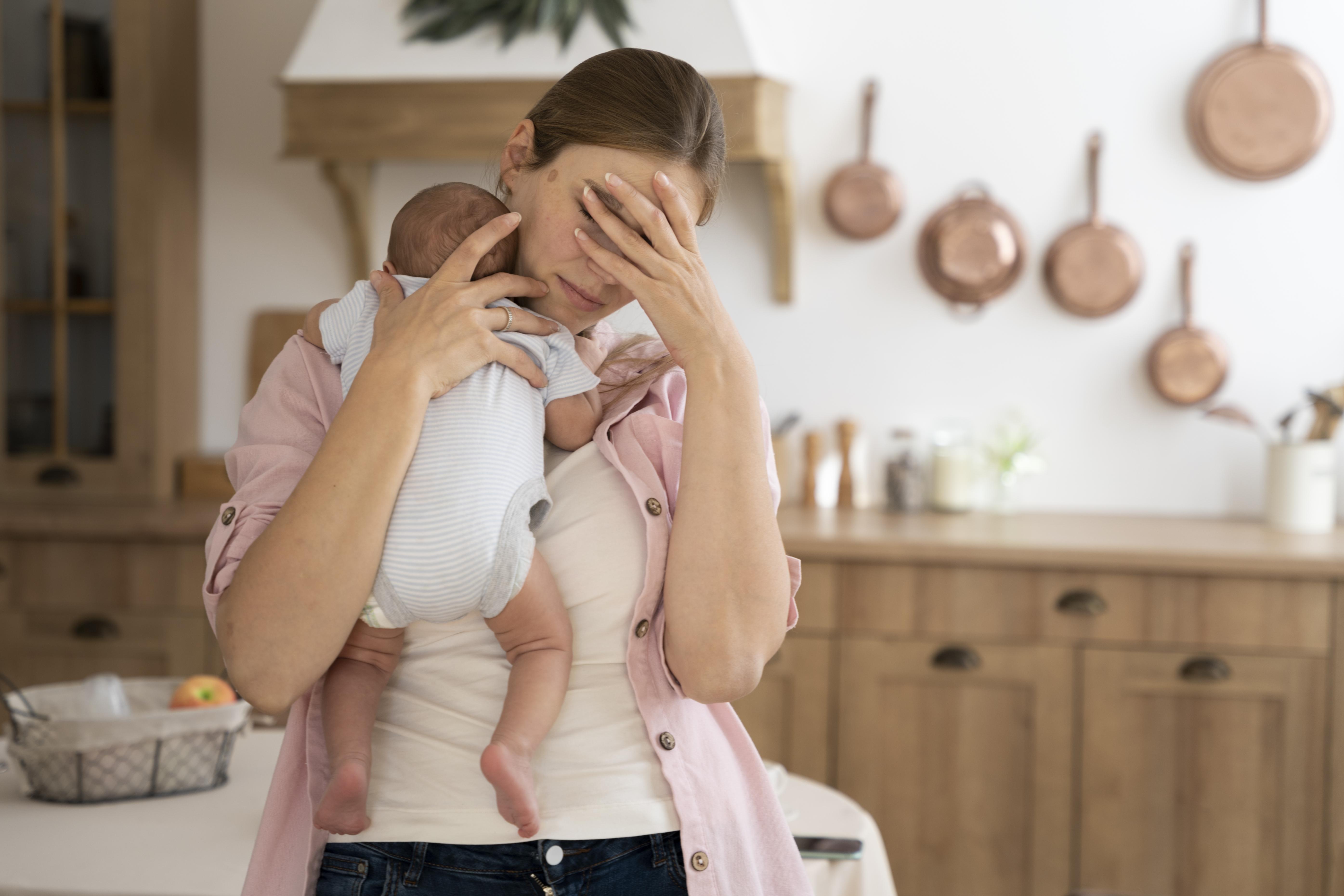 A worried woman with a baby | Source: Freepik