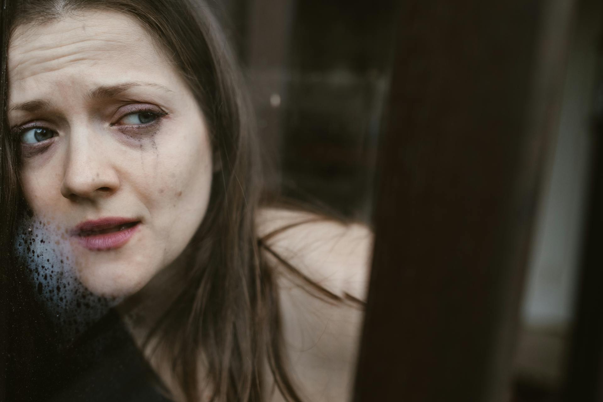 A very stressed woman looking out the window | Source: Pexels