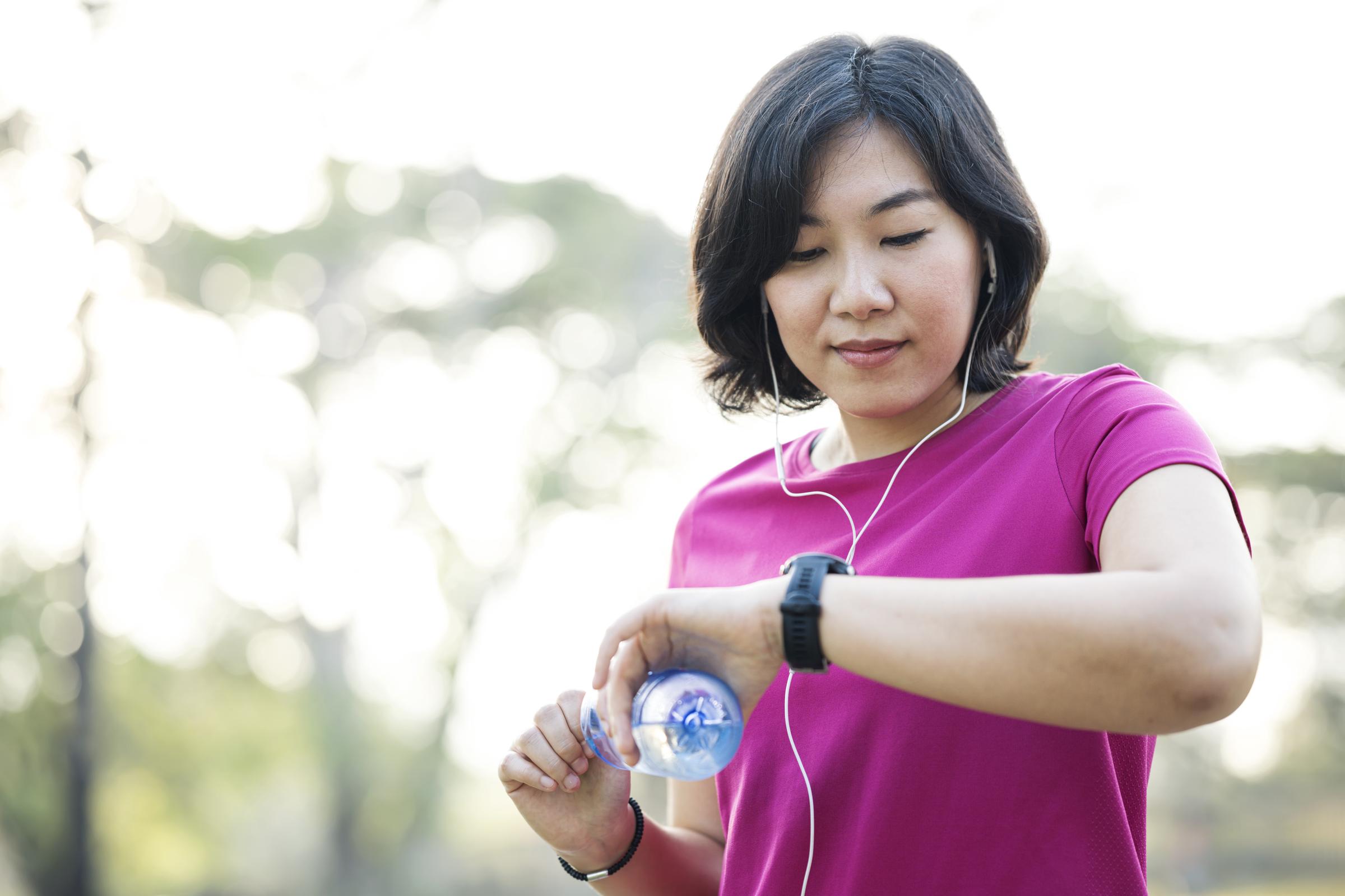 A woman checking her smartwatch during a jog | Source: Getty Images