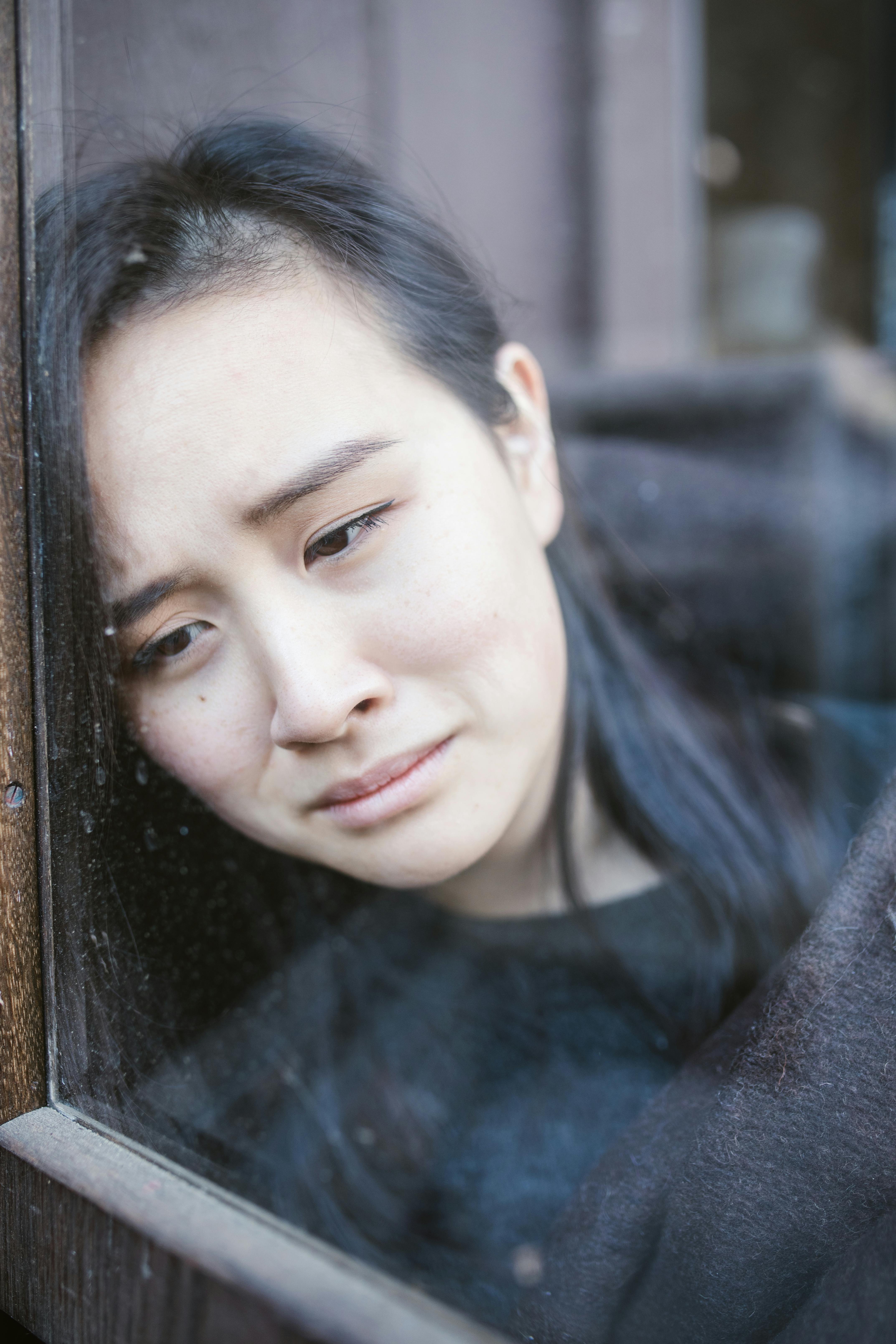 A sad woman looking out a window | Source: Pexels