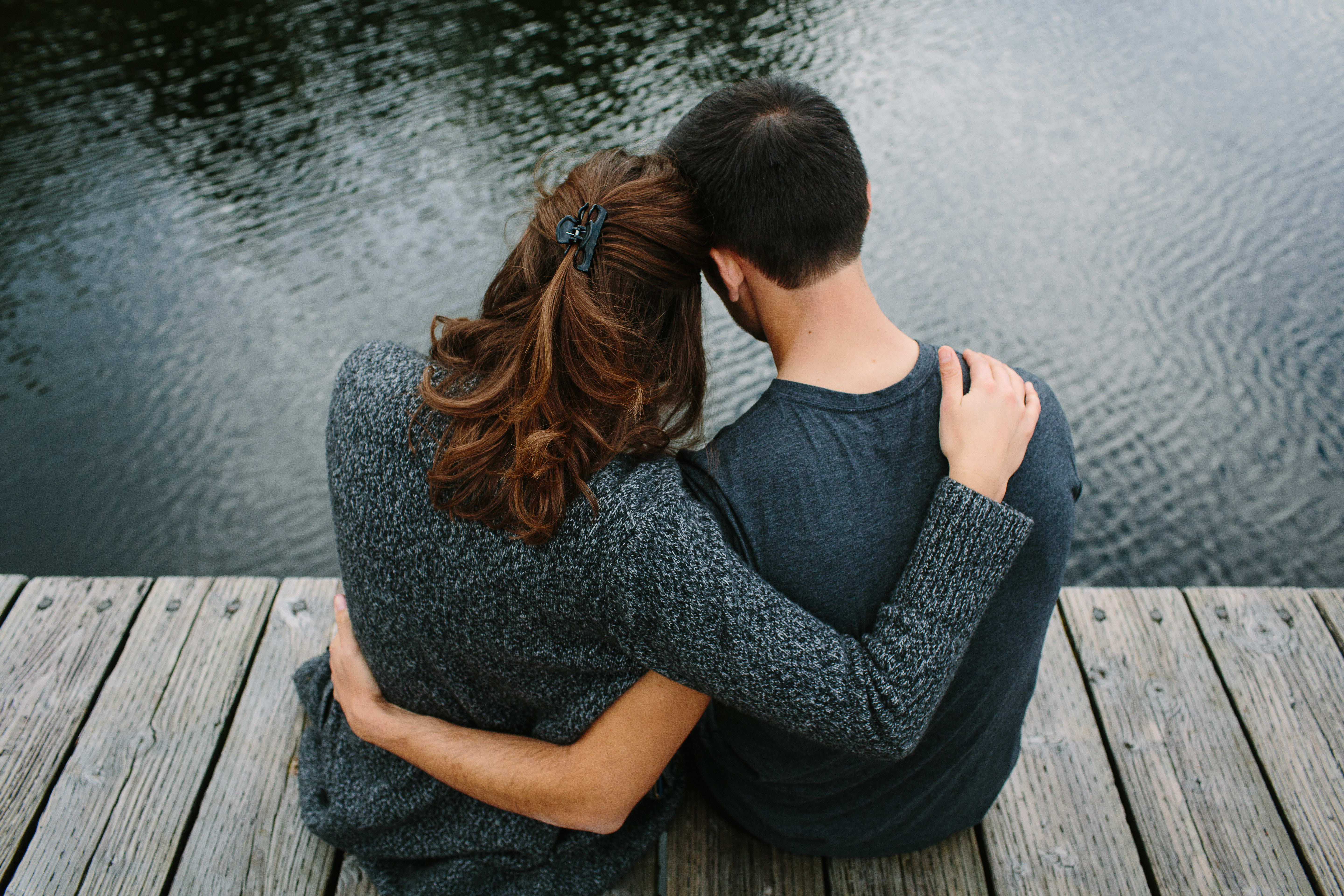 Foto eines kuschelnden Paares auf dem Pier | Quelle: Shutterstock