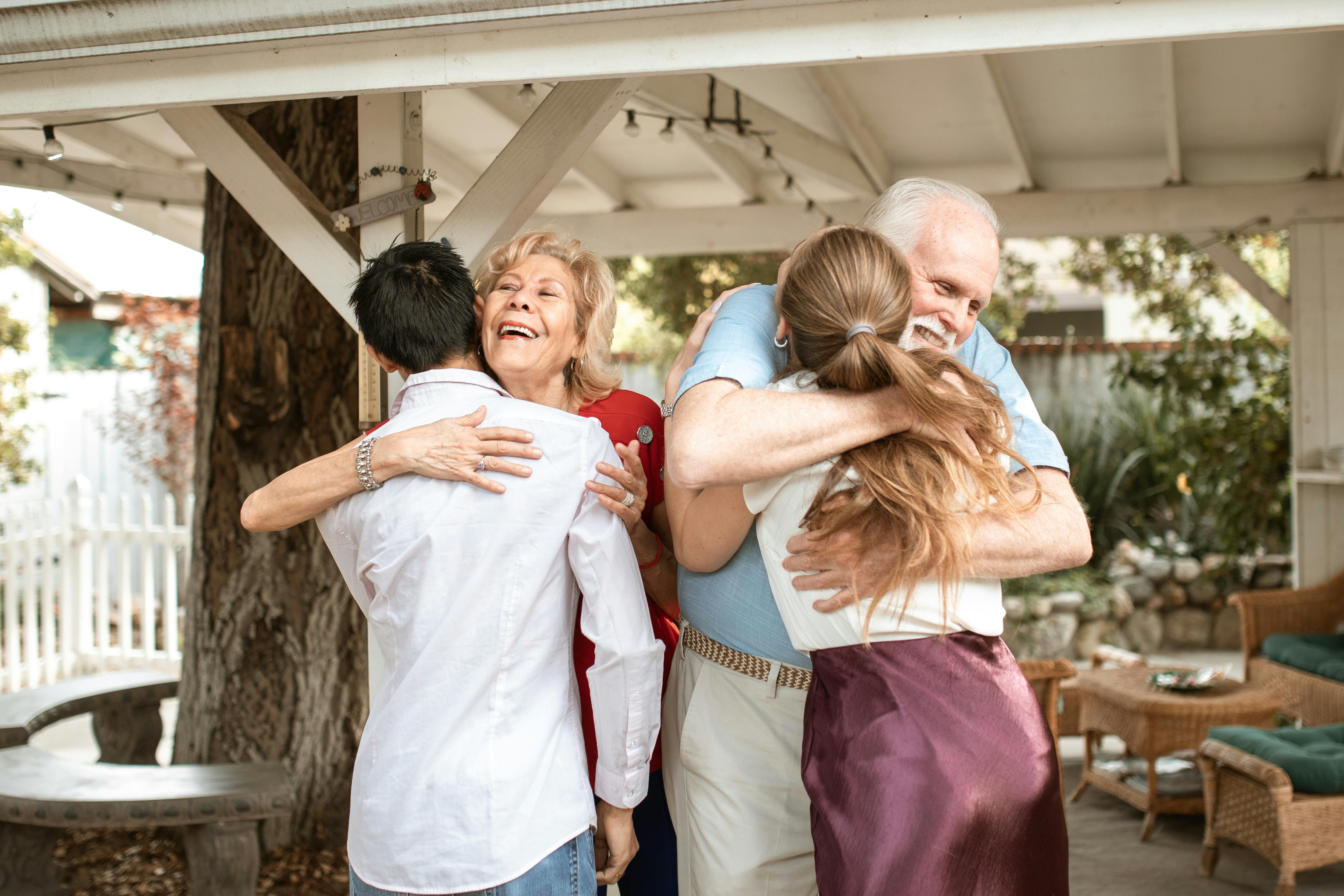 A young couple exchanging hugs with elderly couple | Source: Pexels