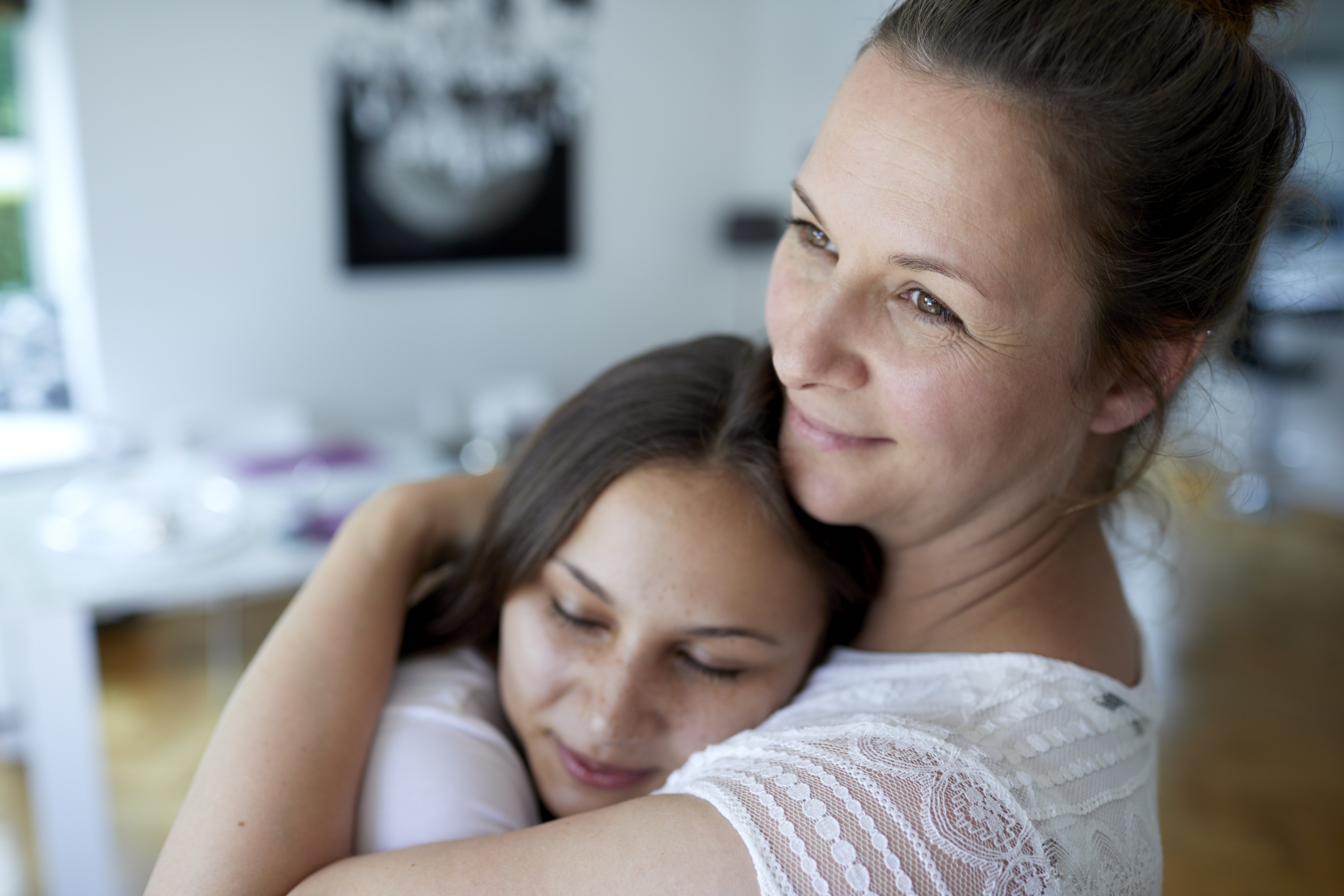 Mother and teenage daughter embracing at home|Photo: Getty Images