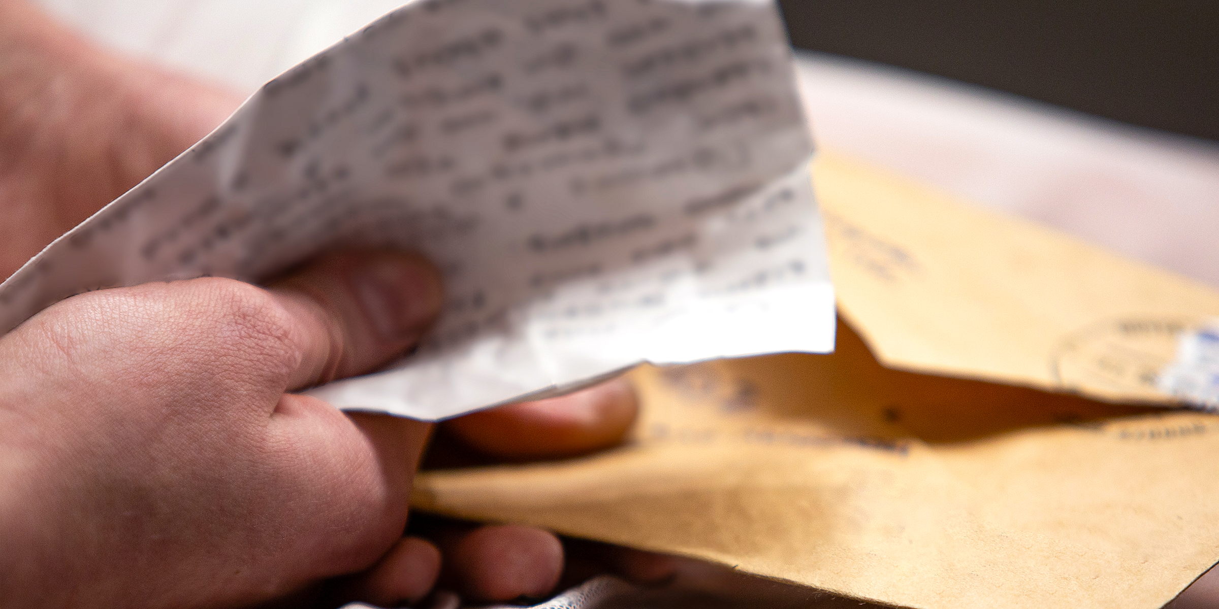 A man holding a note and an envelope | Source: Shutterstock