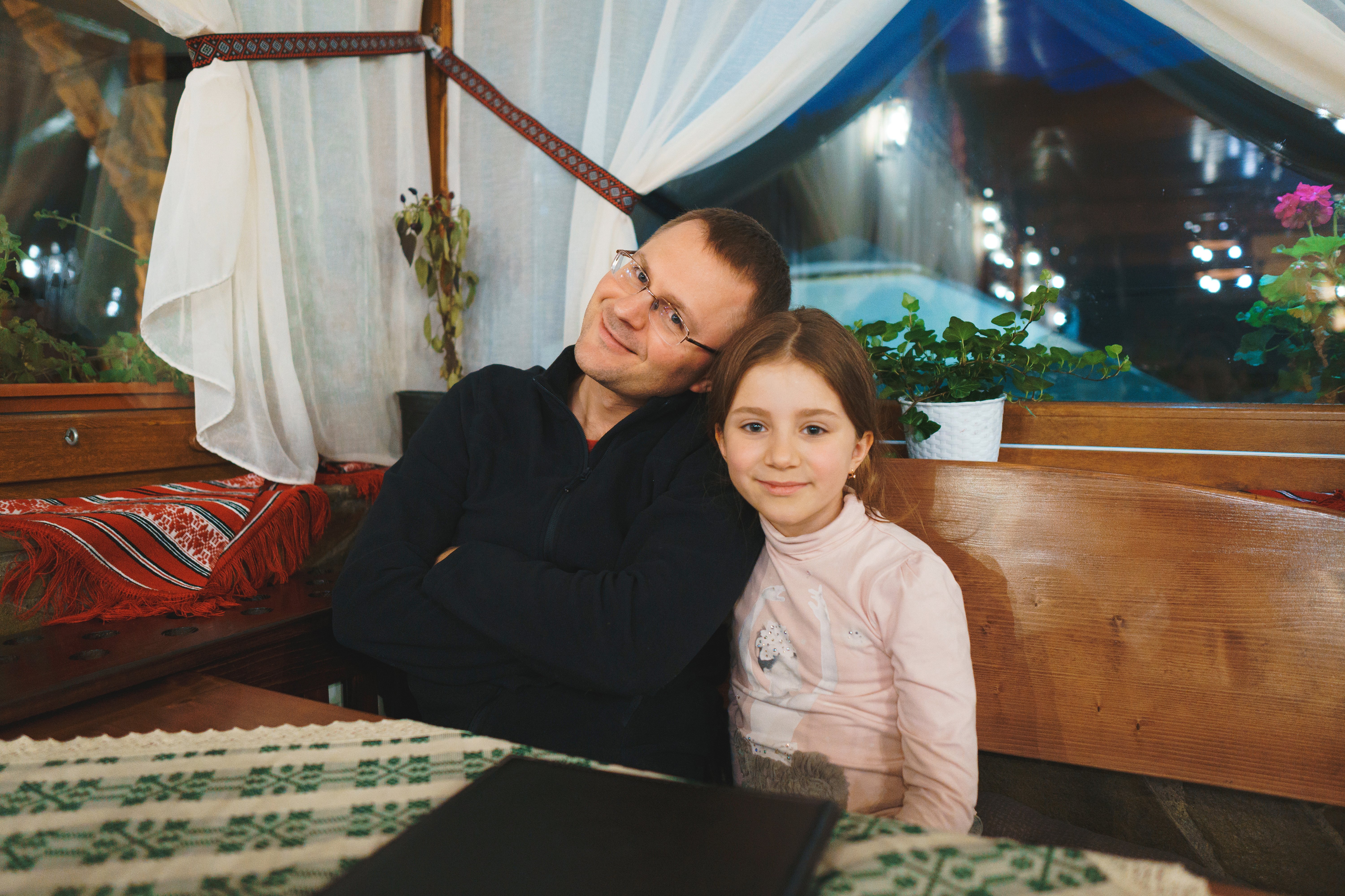 A little girl and her father sit together. | Source: Shutterstock