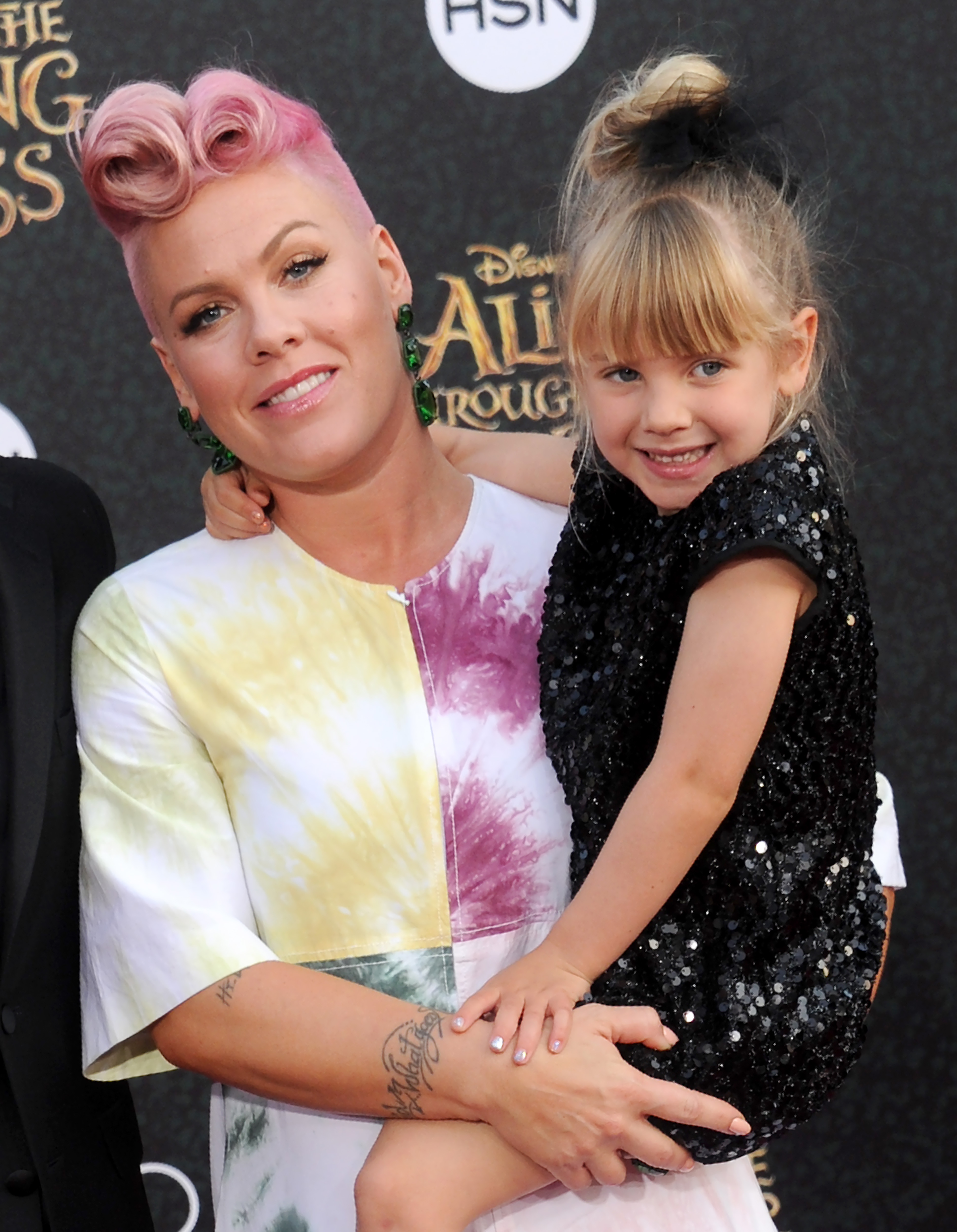 Pink holds Willow Sage Hart at Disney's "Alice Through the Looking Glass" premiere on May 23. Pink wears pink-styled hair and a pastel dress, while Willow smiles in a black sequined outfit.