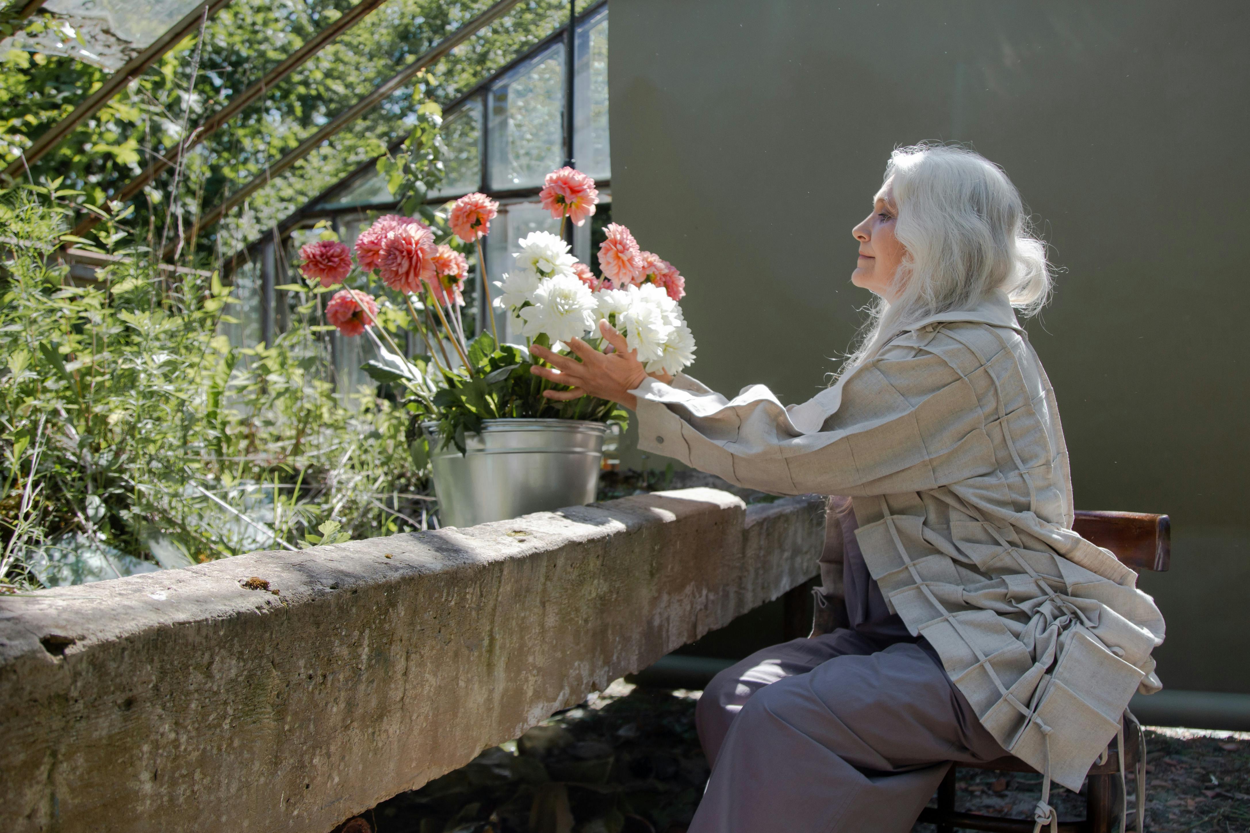 Woman holding flowers in a pot | Source: Pexels
