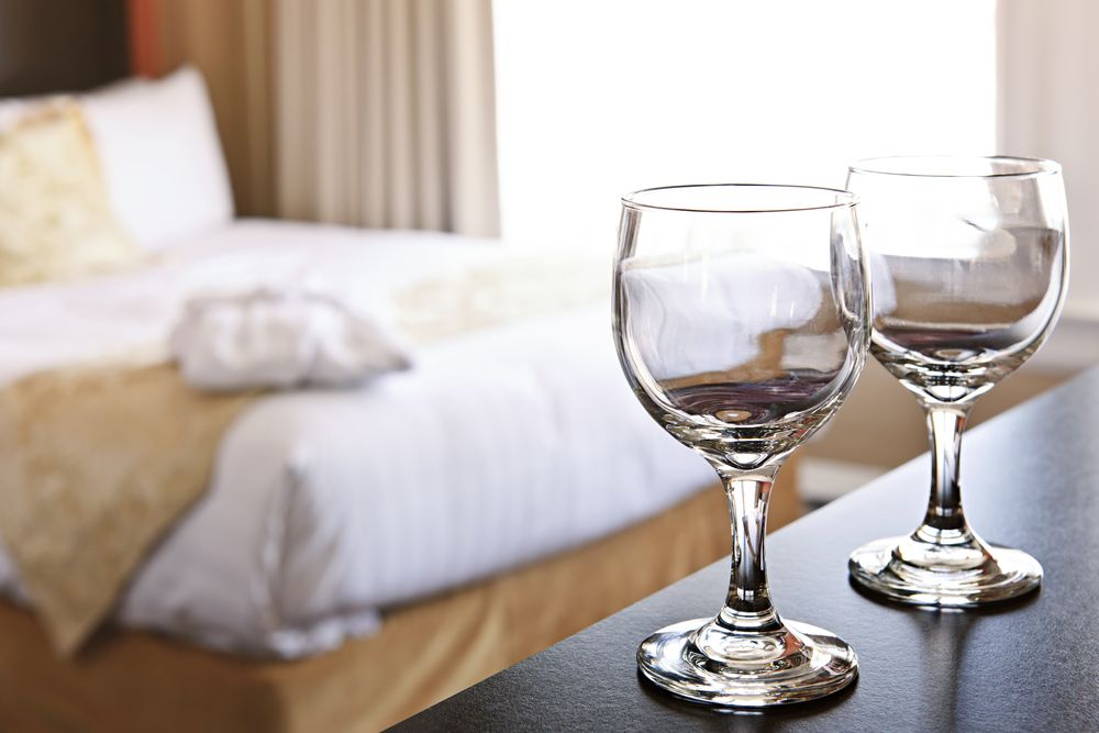 Two empty glass wines in a bedroom. | Source: Shutterstock