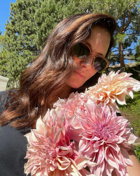 Kristin Davis poses while holding flowers, dated March 20, 2024 | Source: Instagram/iamkristindavis
