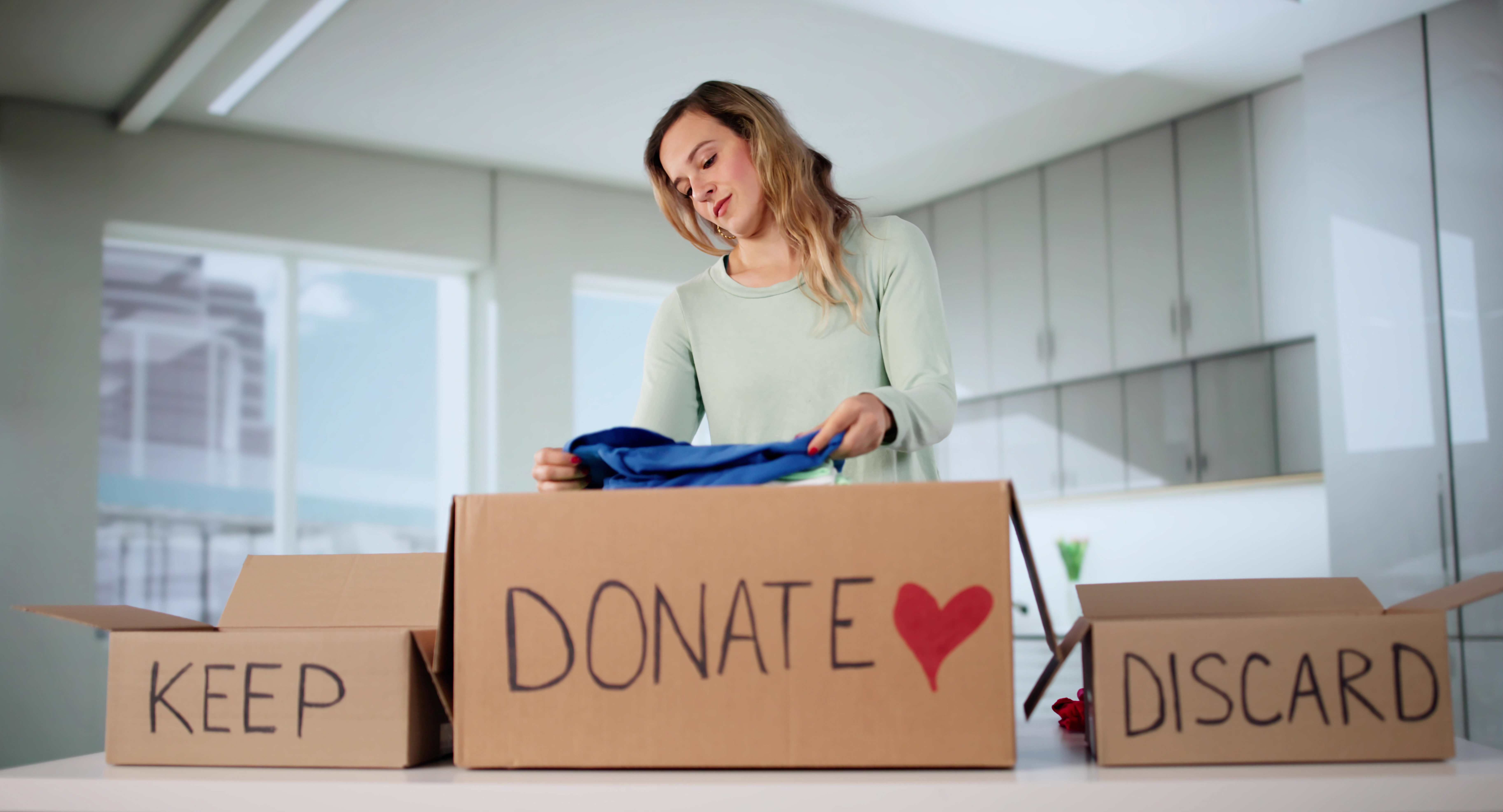 A woman sorting through clothes to keep, donate, and discard | Source: Getty Images