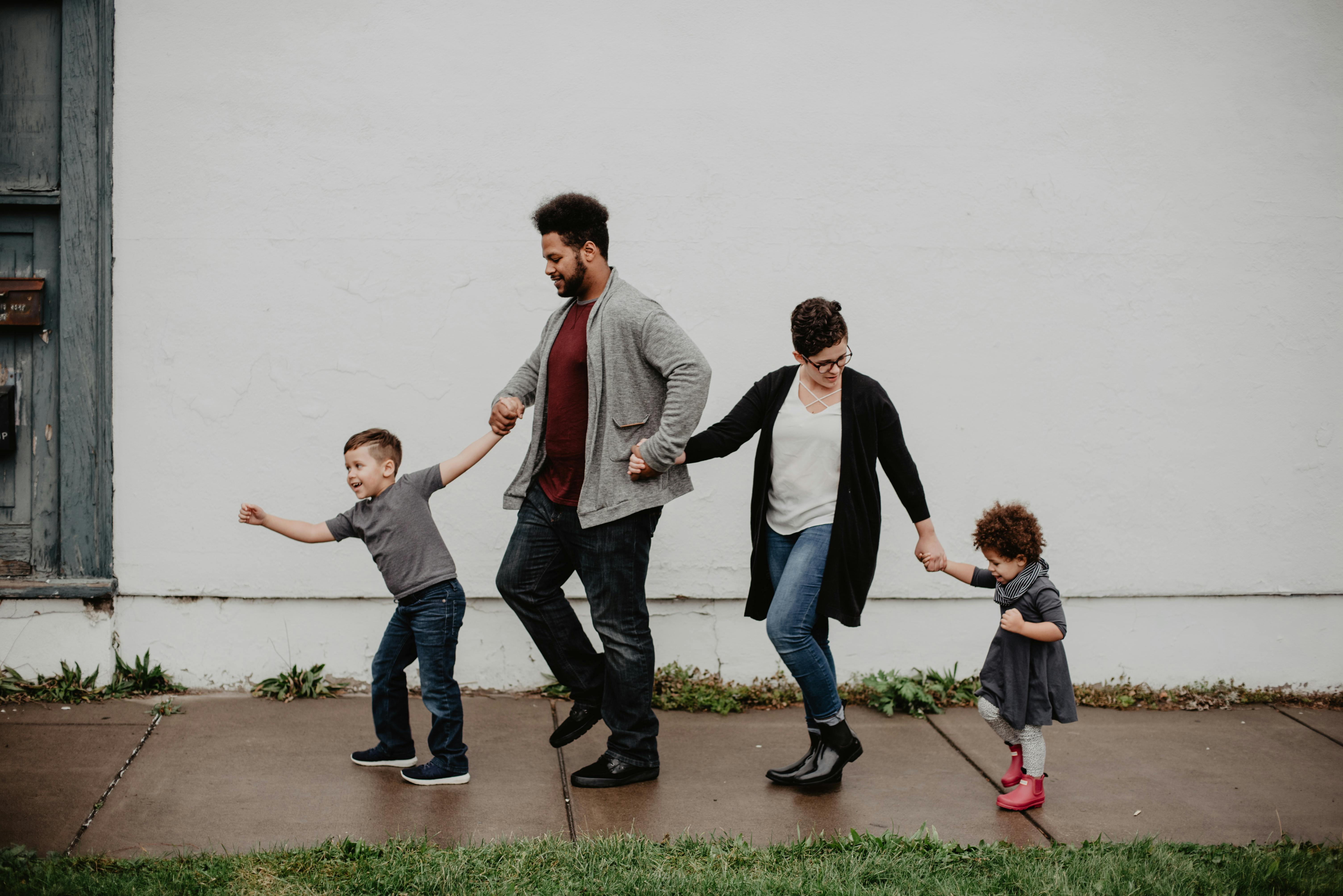 A family of four holding hands and walking | Source: Pexels