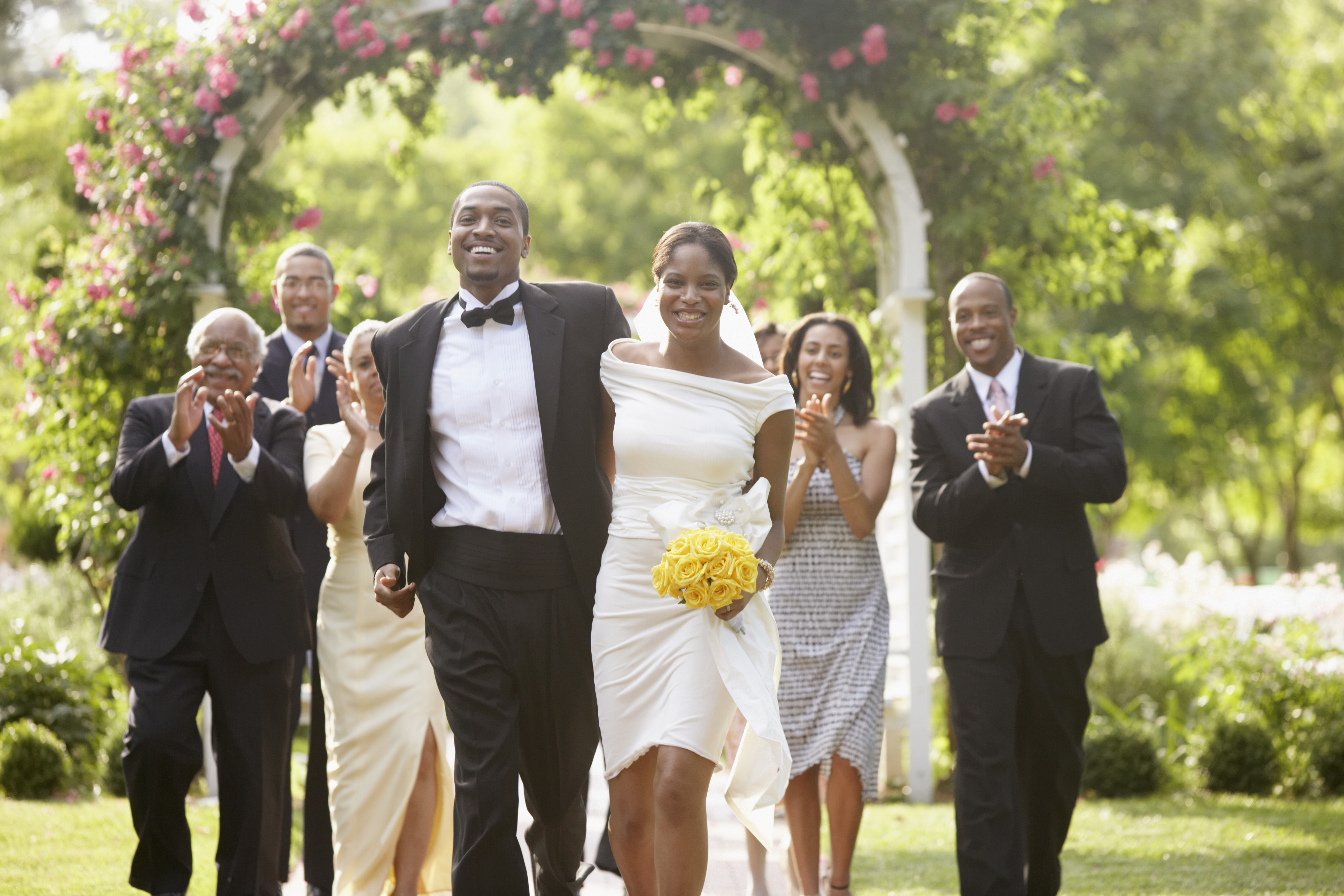 Wedding guests applauding newlyweds | Source: Getty Images