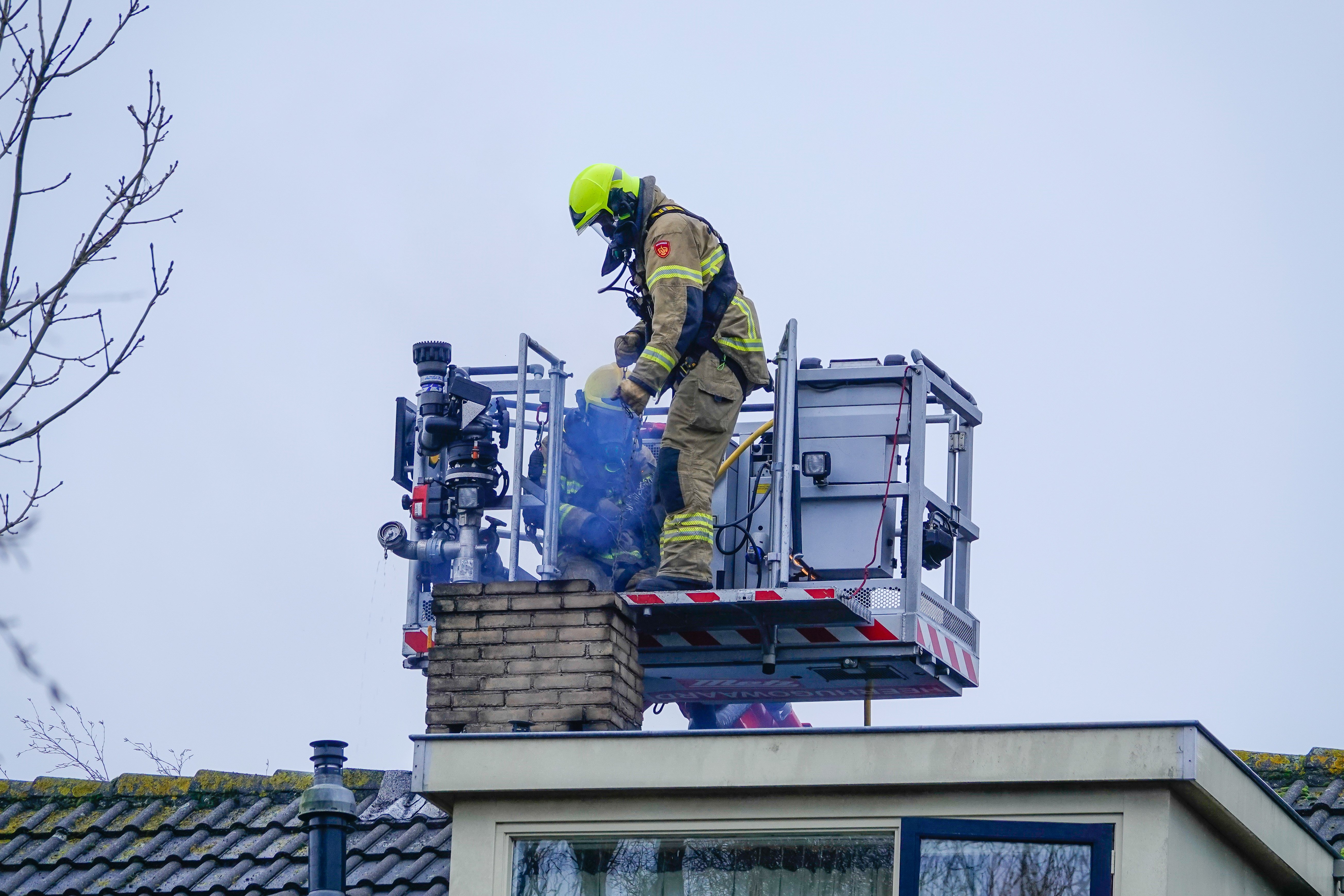 Firemen rescuing a man stuck in the chimney | Source: Shutterstock