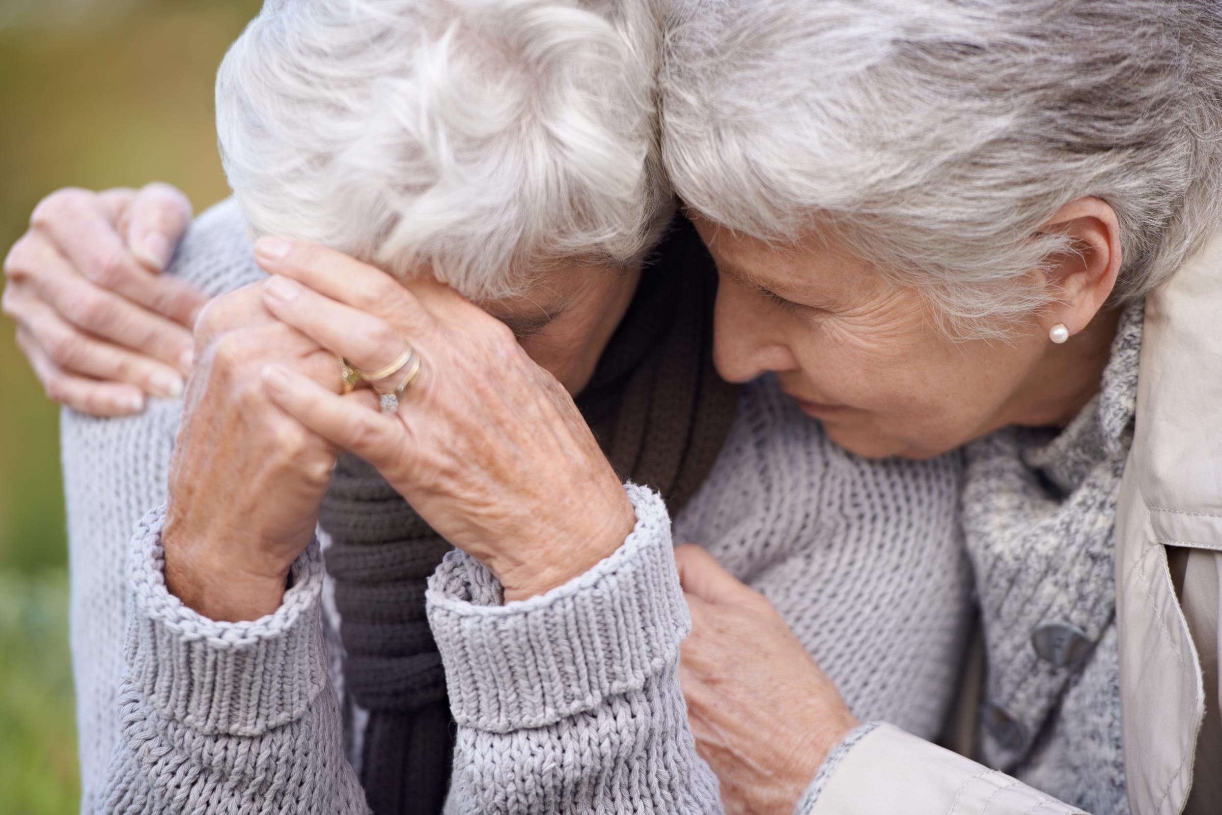A senior woman consoling a grieving loved one | Source: Shutterstock