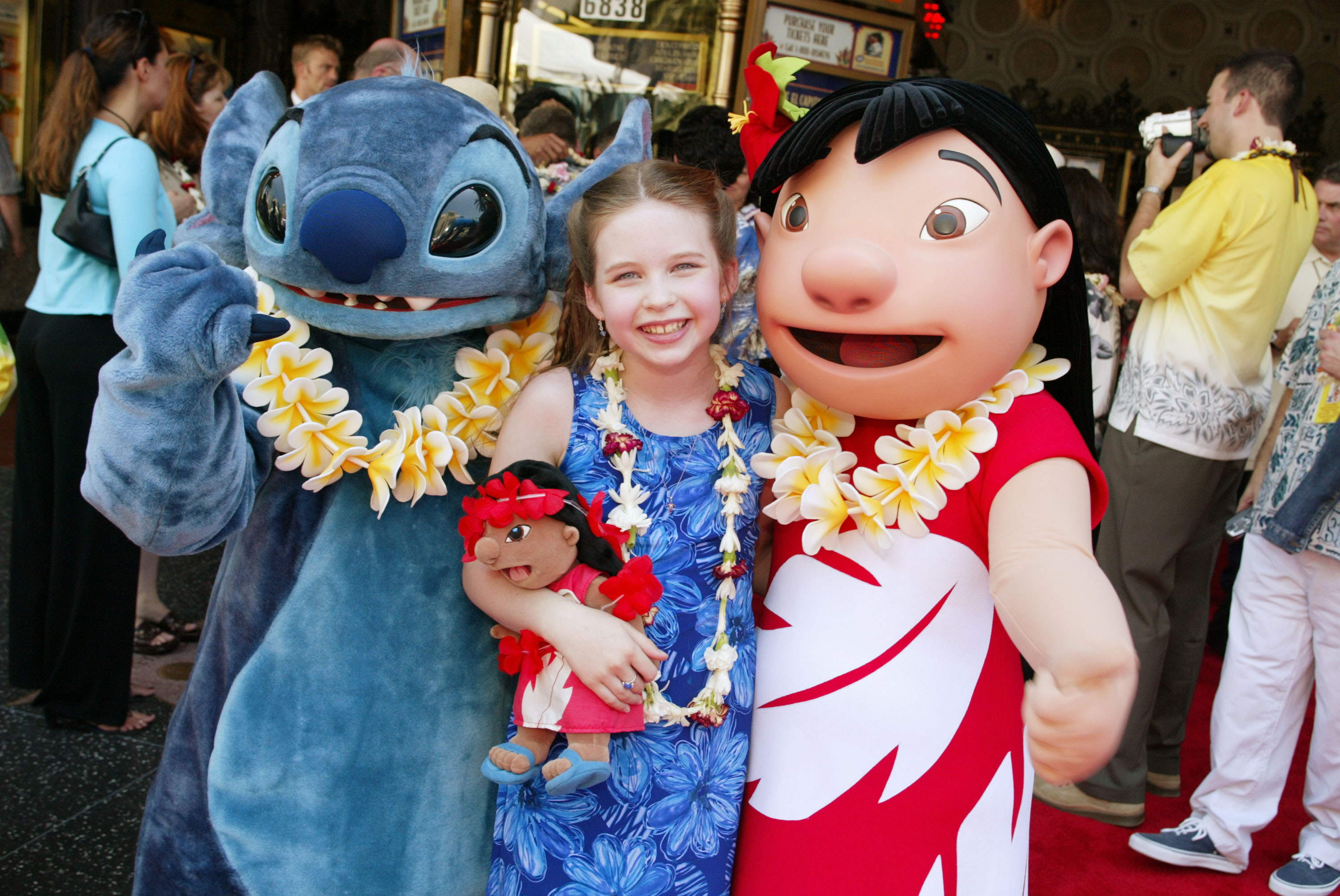 Daveigh Chase smiles between Stitch and Lilo mascots while attending the premiere and after-party for "Lilo & Stitch" at the El Capitan Theatre in Los Angeles, shortly after bringing the animated heroine to life on screen. | Source: Getty Images
