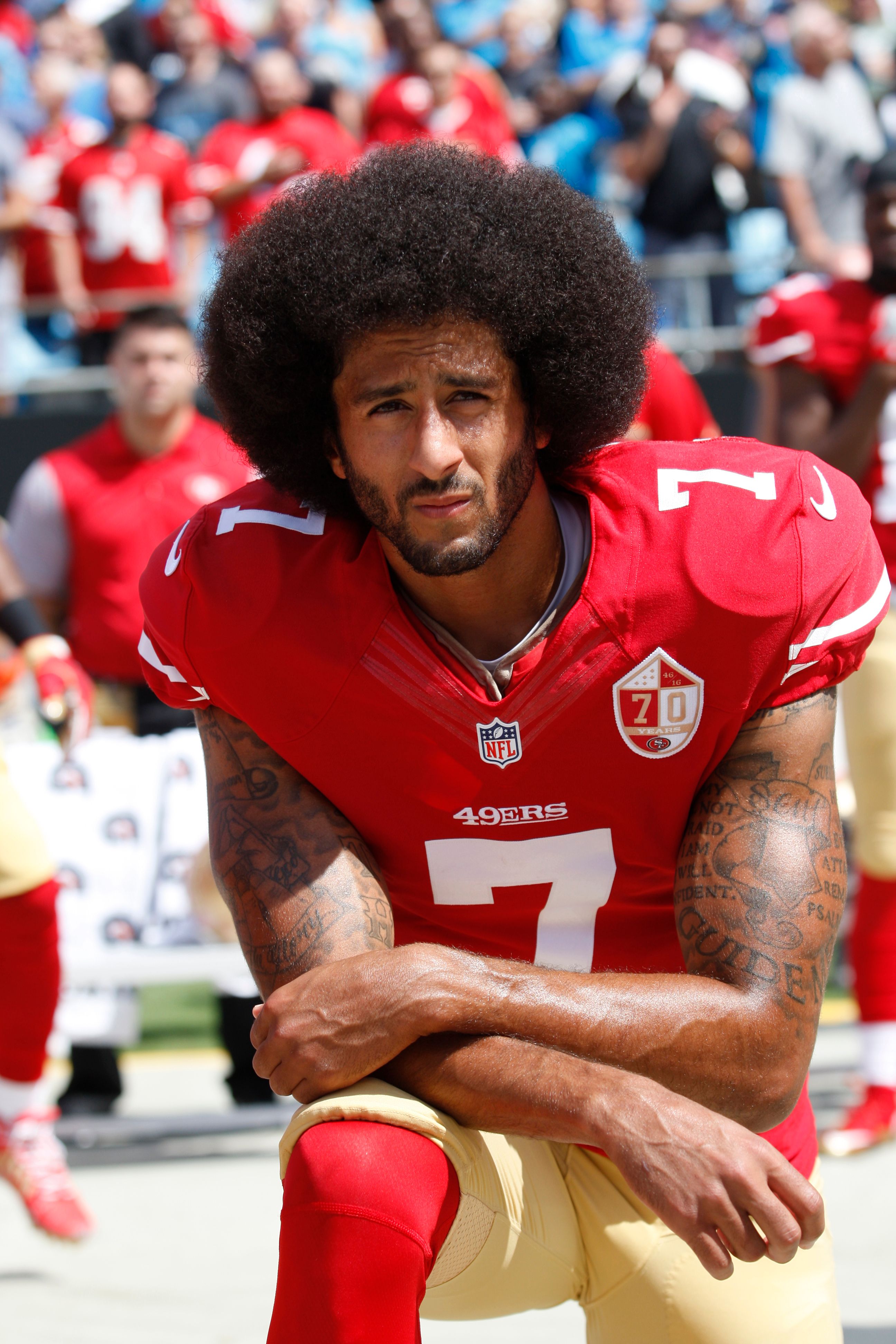 Colin Kaepernick kneels down during a San Francisco 49ers game in protest of police brutality | Source: Getty Images