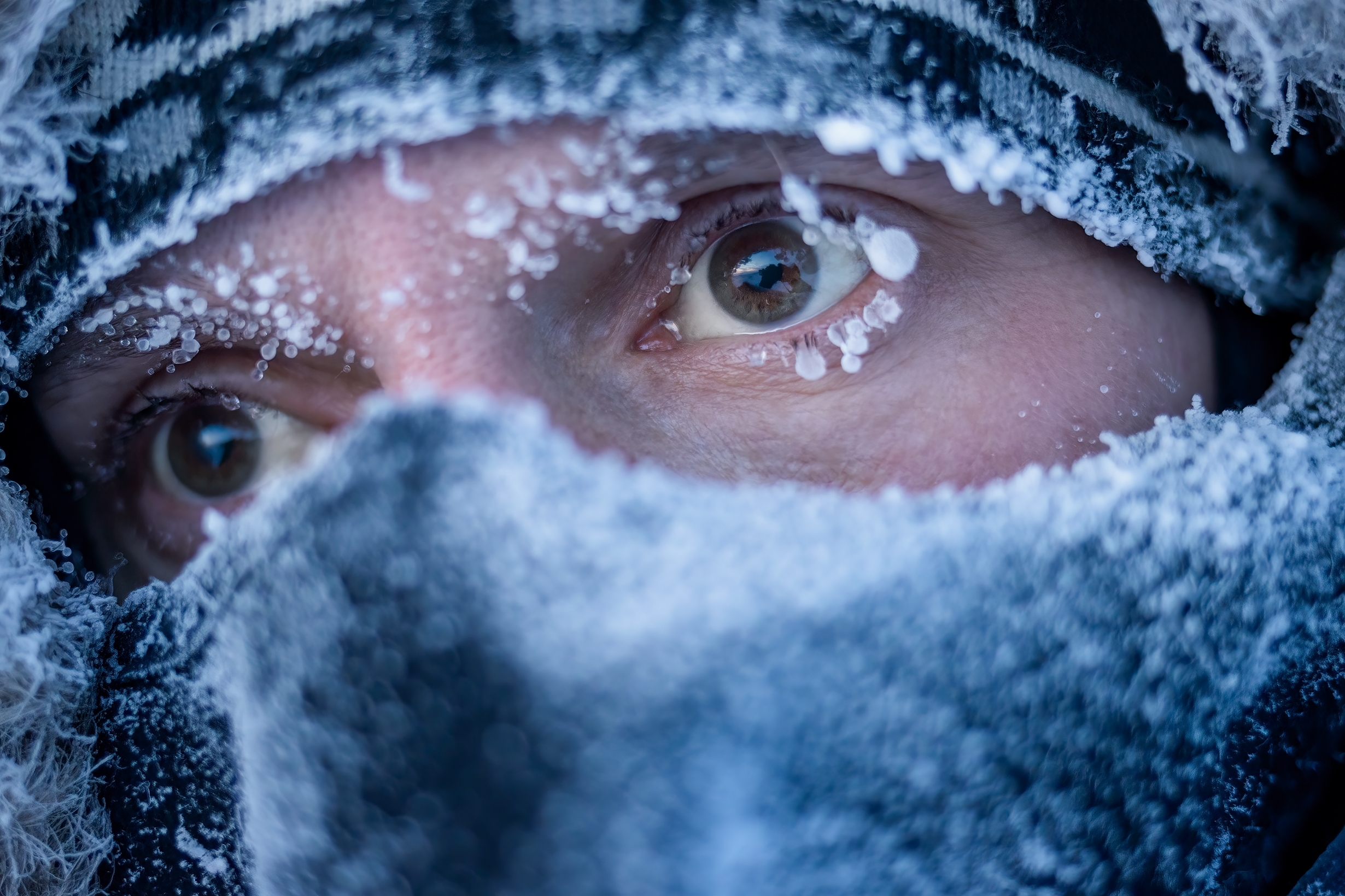 A man's masked-up face on a snowy day. | Source: Shutterstock