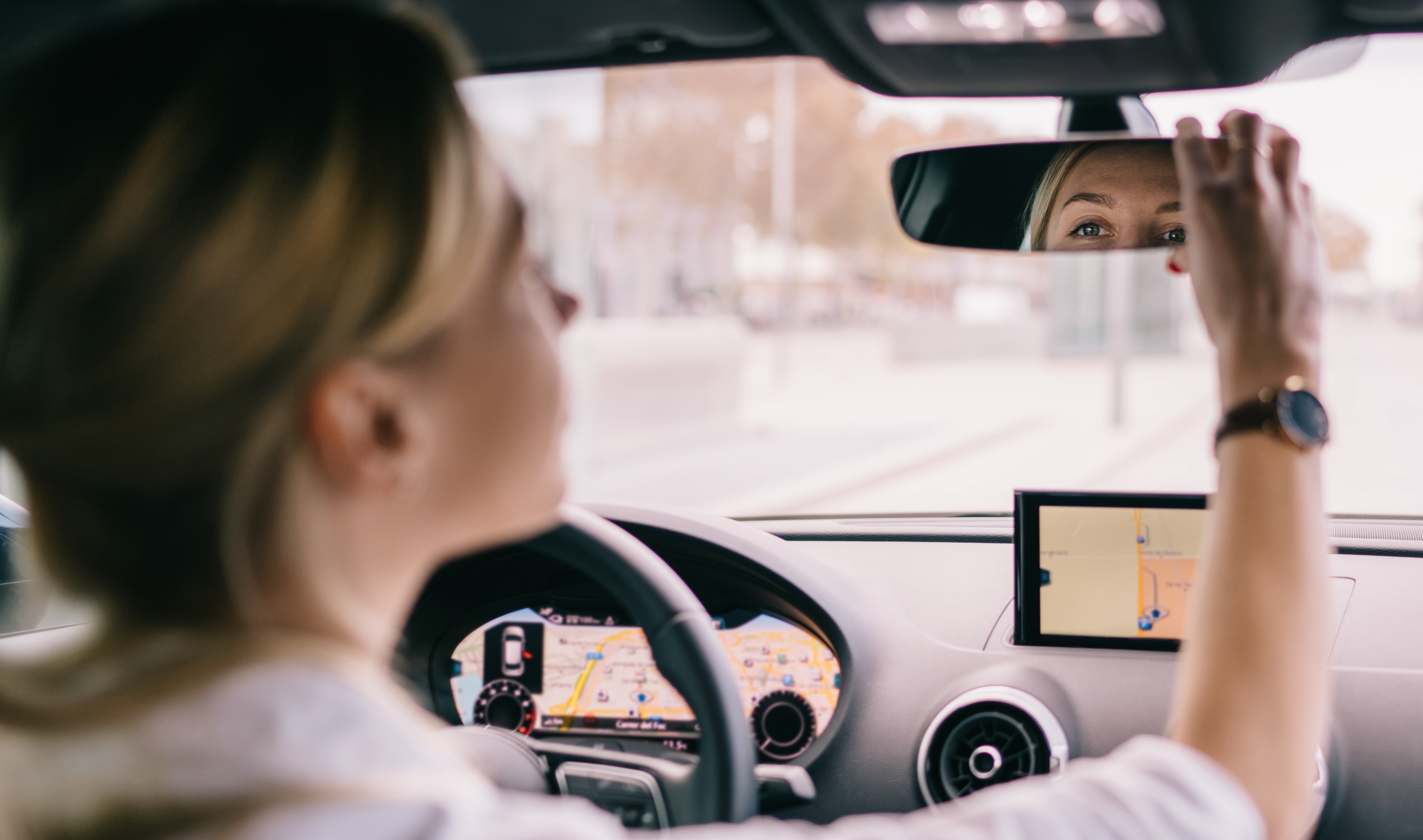 A woman driver adjusting the rearview mirror | Source: Shutterstock