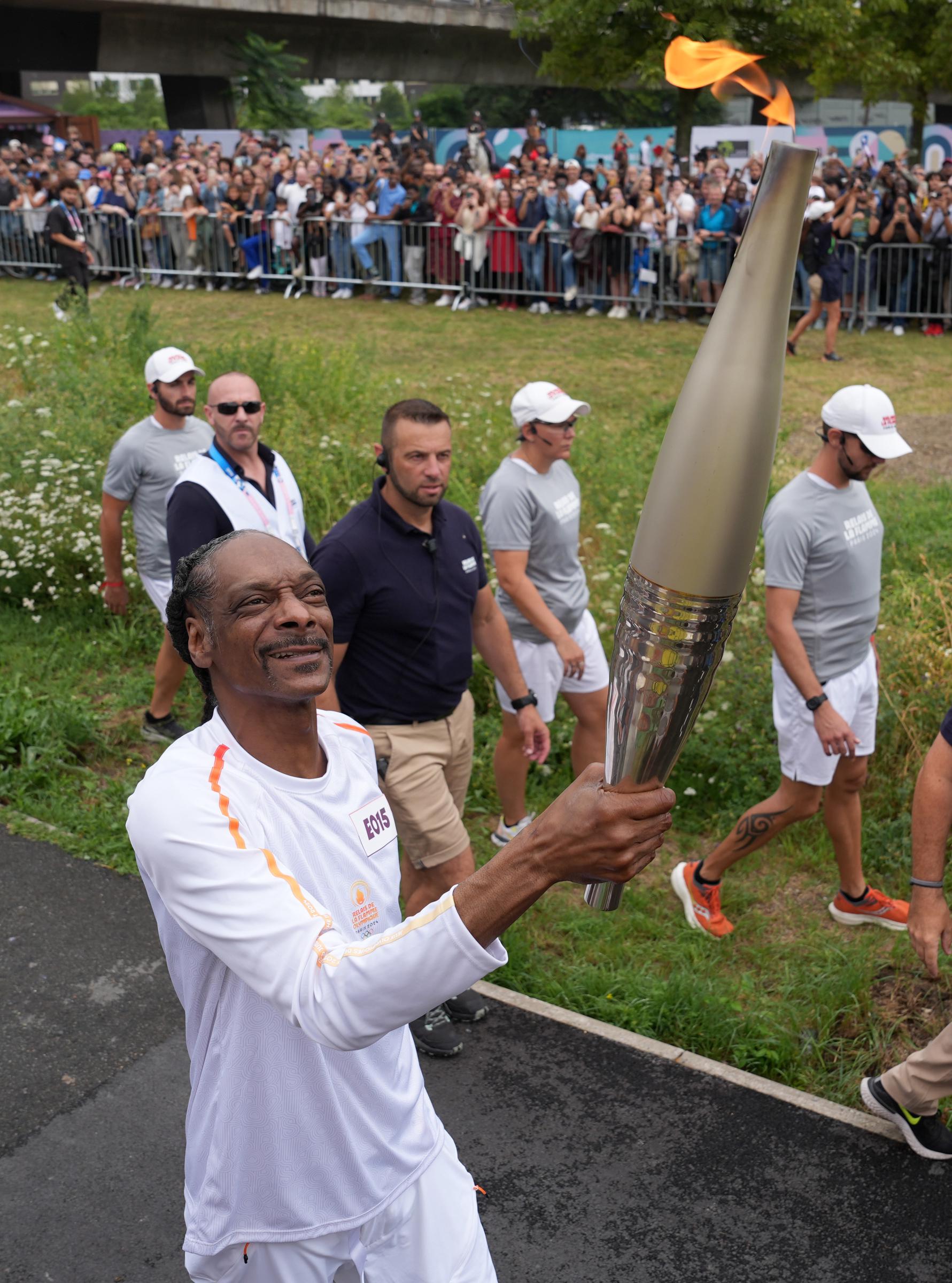 Snoop Dogg carries the torch during the torch relay at the Paris 2024 Olympics on July 26, 2024, in Paris, France. | Source: Getty Images