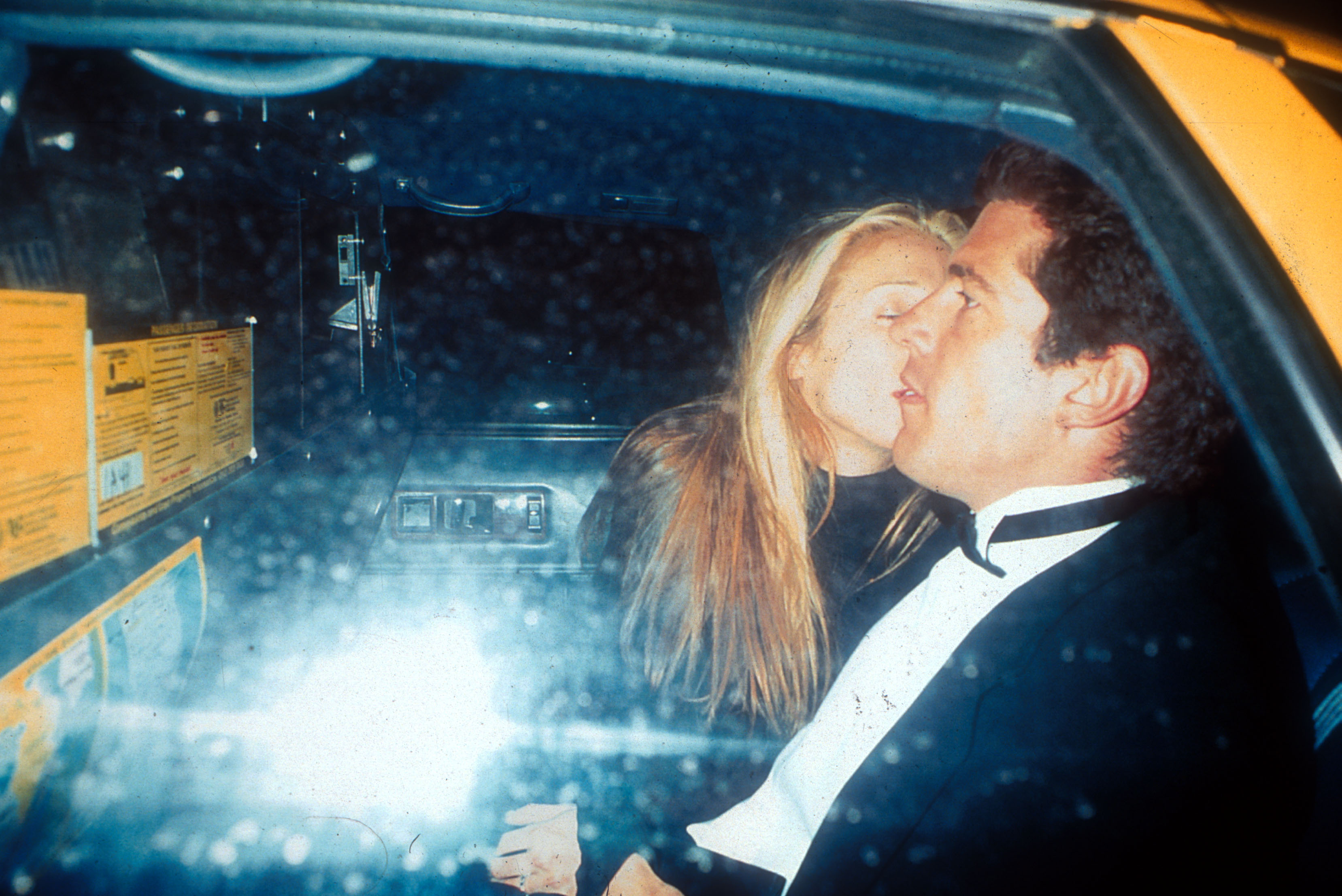 Caroline Bessette photographed planting a kiss on John F. Kennedy Jr.'s cheek in the back of a taxi in New York on March 11, 1996. | Source: Getty Images