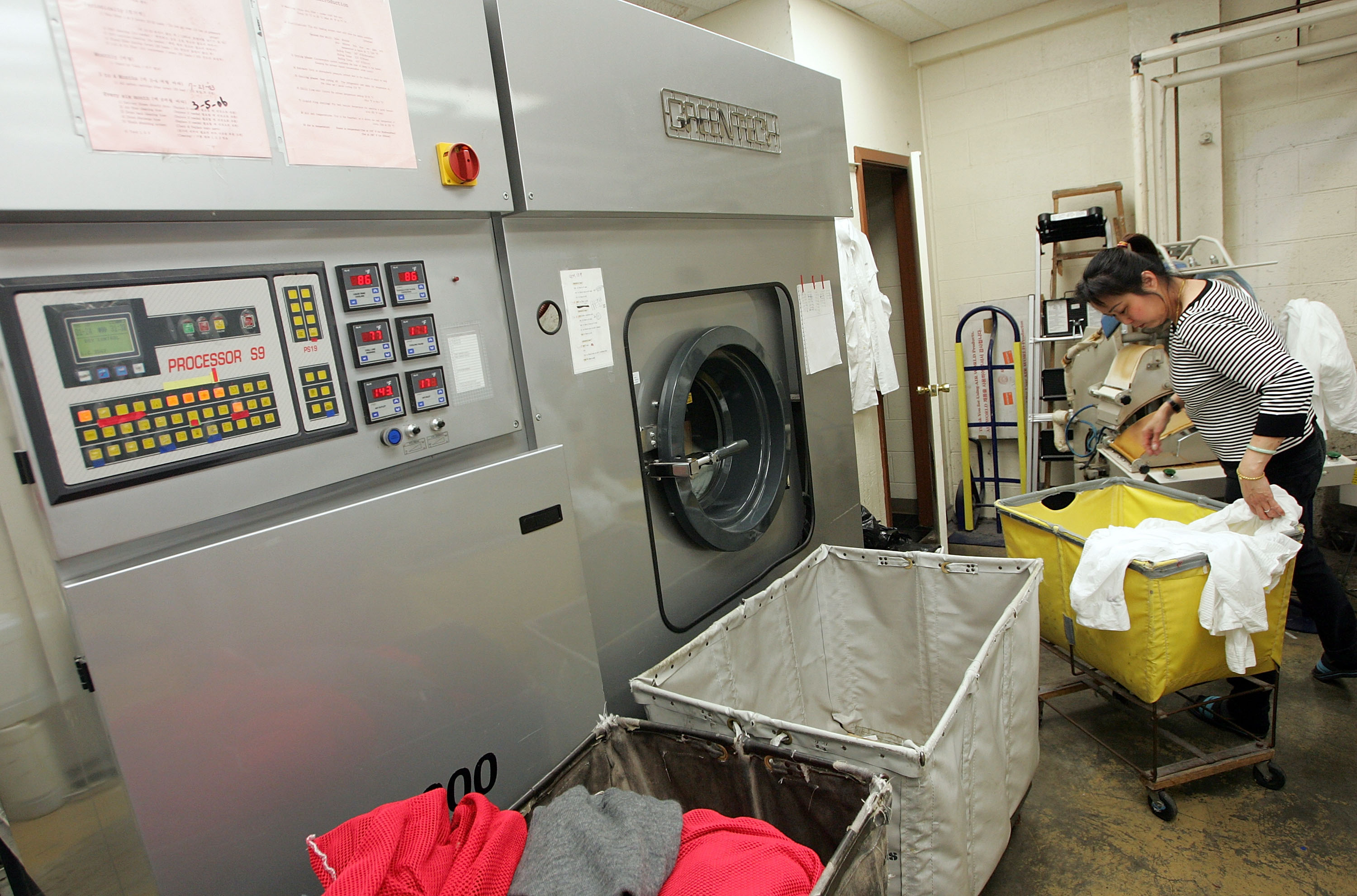 A worker at Sohn's French Cleaners sorting clothes next to a dry clean machine | Source: Getty Images