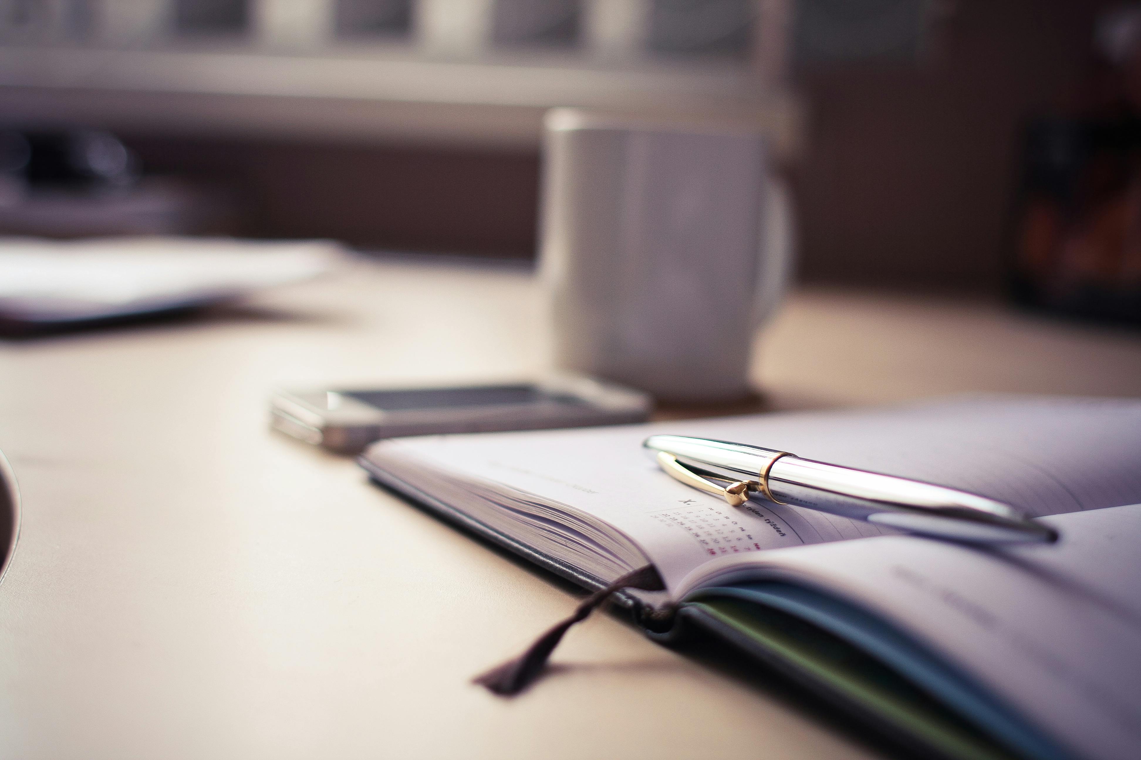 A pen and a notebook on a table | Source: Pexels