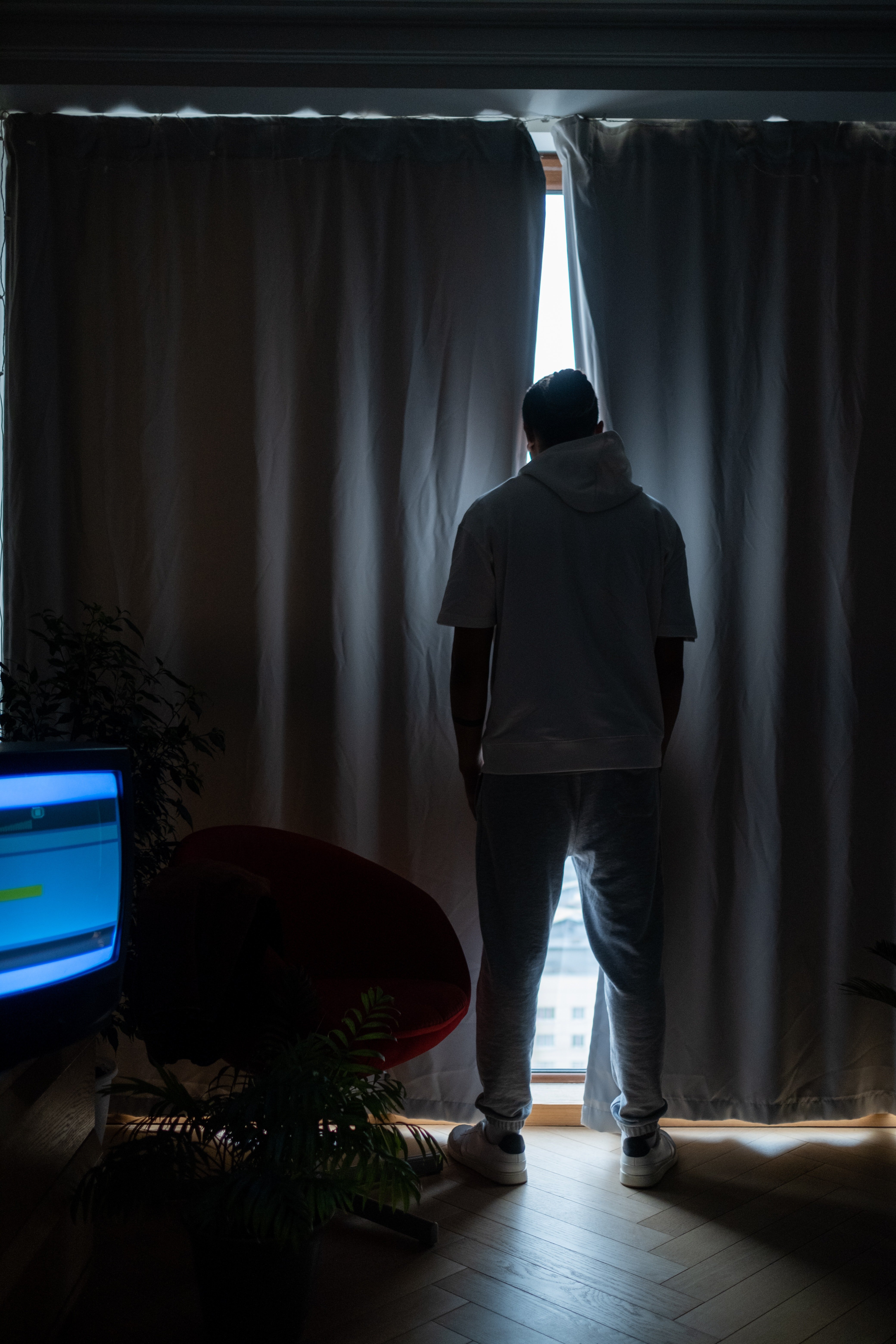 Hombre de pie en la ventana de una habitación. | Foto: Pexels