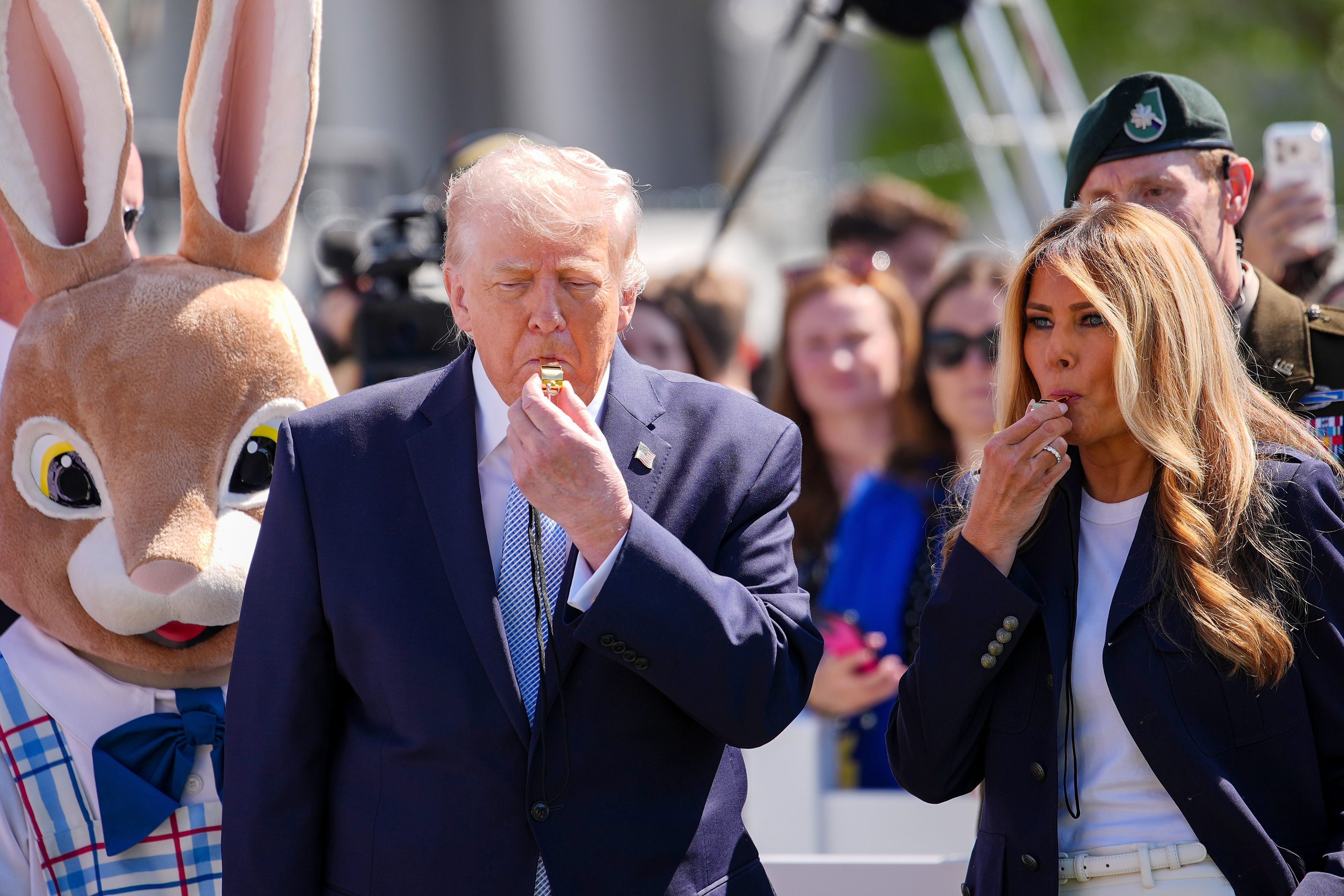 Donald and Melania Trump blow whistles beside the Easter Bunny, helping kick off a children's race on the South Lawn.