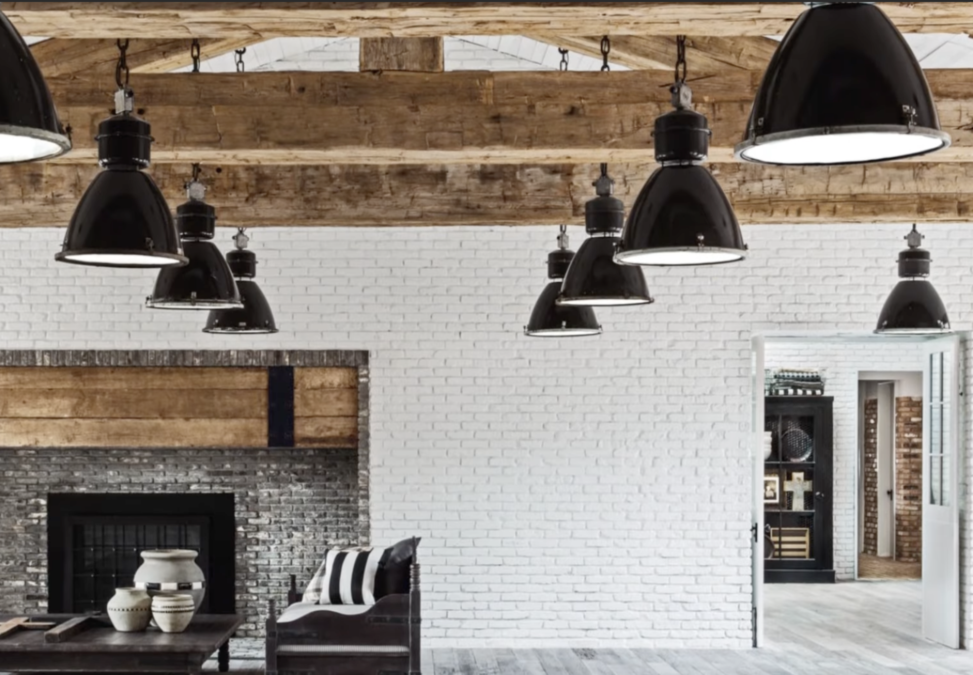 Living area with exposed wood beams and industrial pendant lighting inside Diane Keaton’s Sullivan Canyon home, dated February 3, 2022 | Source: YouTube/@FamousEntertainment500k