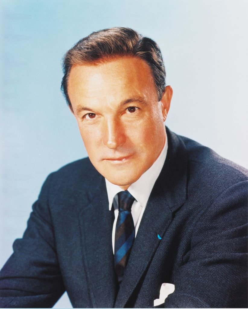 Studio portrait of Gene Kelly wearing a dark blue jacket, white shirt and blue striped tie against a white background, circa 1950. | Photo: Getty Images