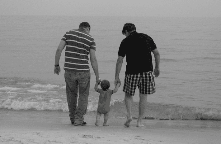 Dads taking their son on a walk on the beach | Source: Pixabay