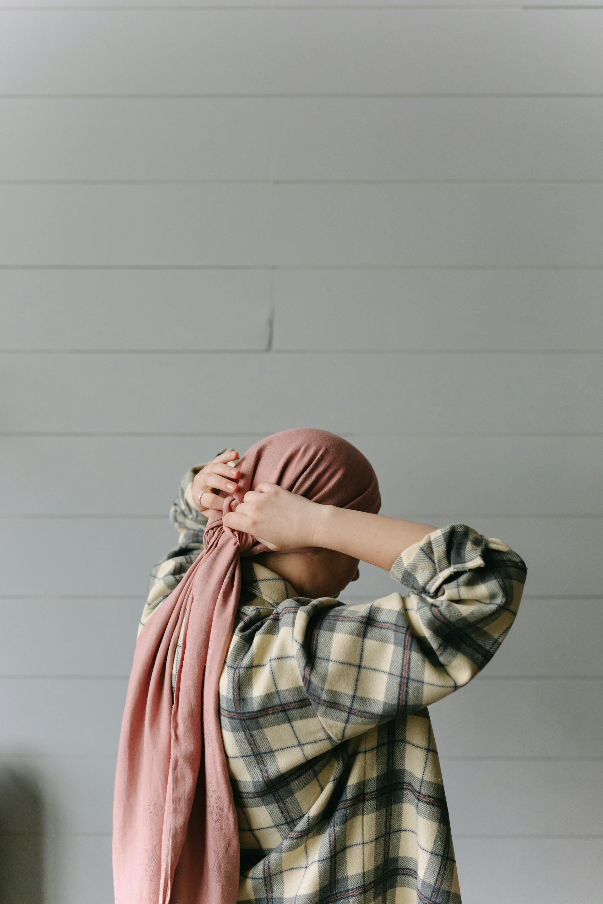 A woman putting on a headscarf | Source: Pexels