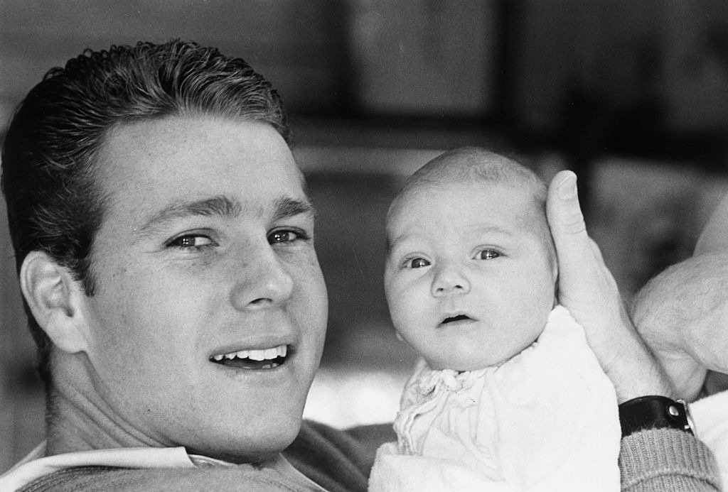 Actor Ryan O'Neal smiling and supporting the head of his eight month-old baby, Griffin. | Photo: Getty Images