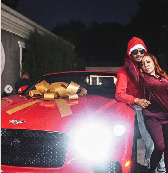 Tameka 'Tiny' Harris and T.I pose next to the red Bentley he gifted her on her birthday | Source: Instagram.com/majorgirl