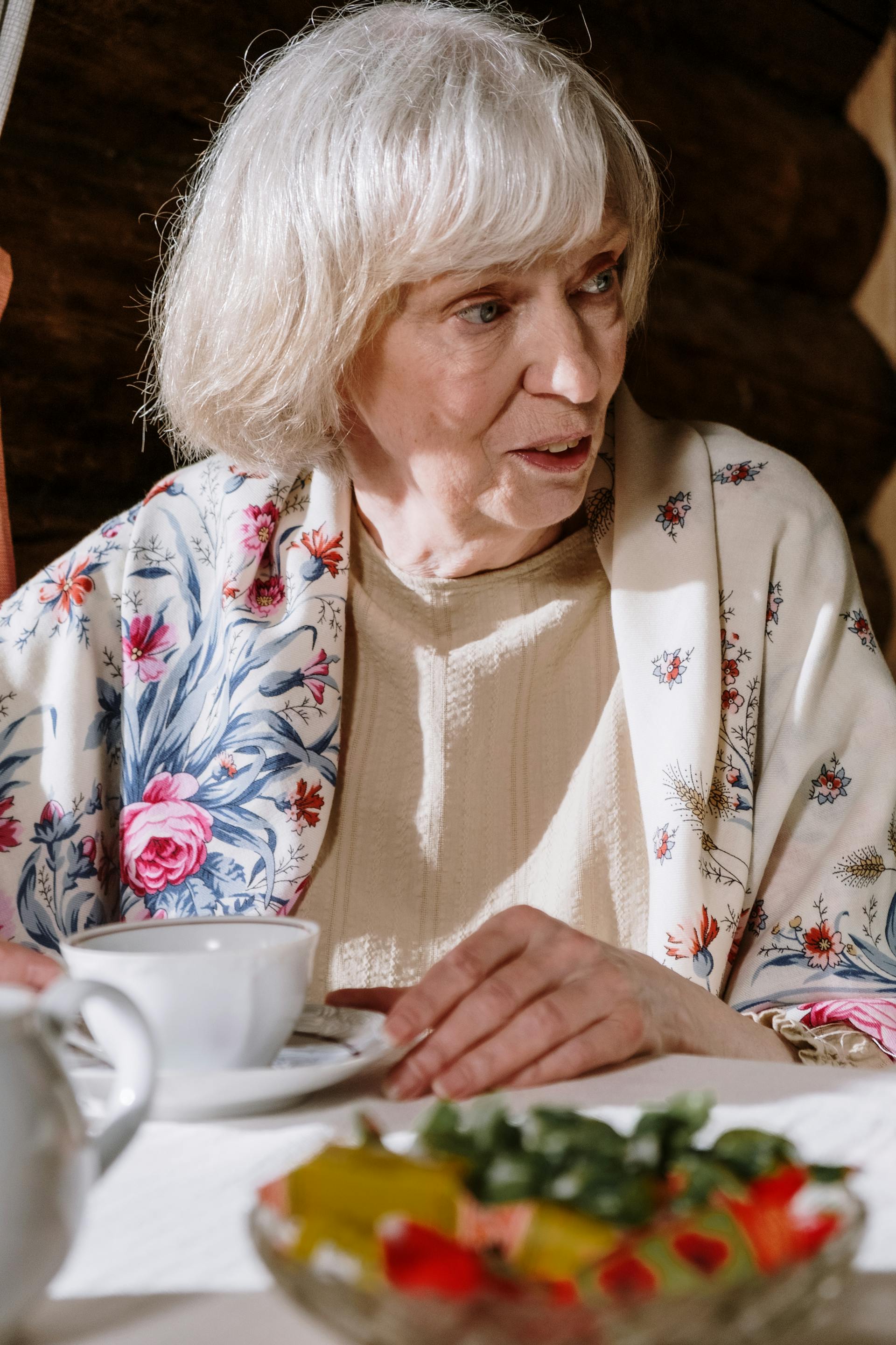 An old woman sitting at a table | Source: Pexels