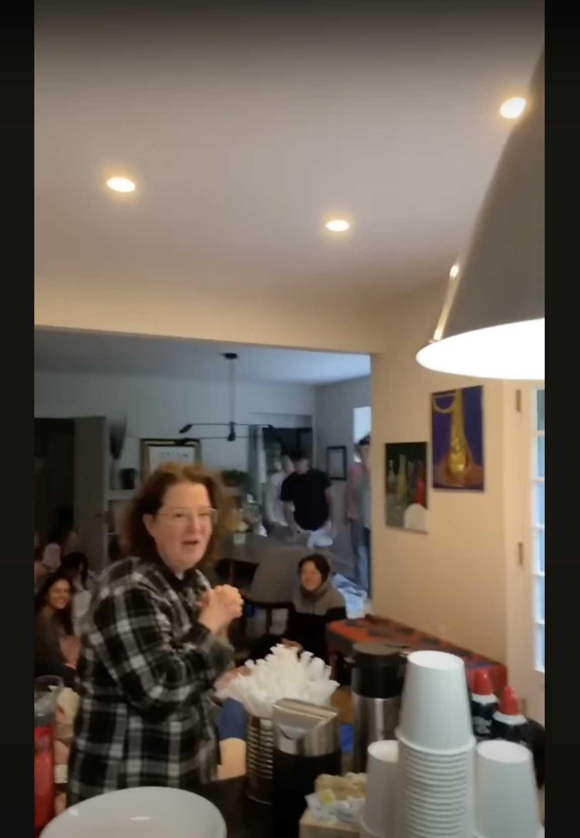Joy McGrath is shocked to see the graduating class of 2023 sprawled on her kitchen floor, as seen in a video dated May 20, 2023 | Source: youtube.com/SASDelaware