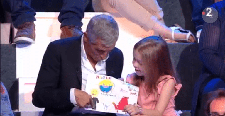 Une fillette avec un dessin et Nagui sur le plateau de France 2. | Photo : vidéo/Gala Une fillette avec un dessin et Nagui sur le plateau de France 2. | Photo : vidéo/Gala
