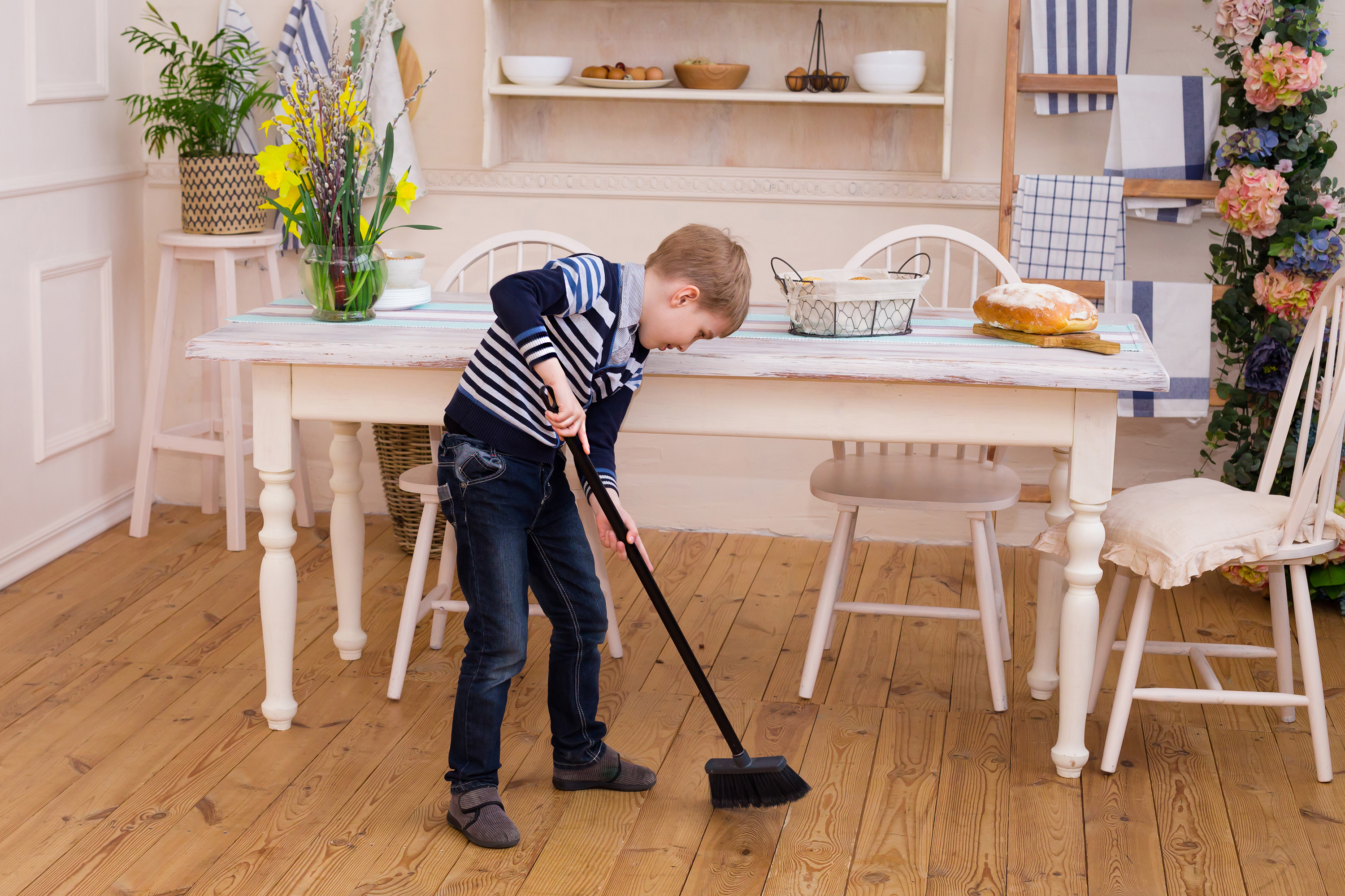 A young boy sweeping | Source: Shutterstock