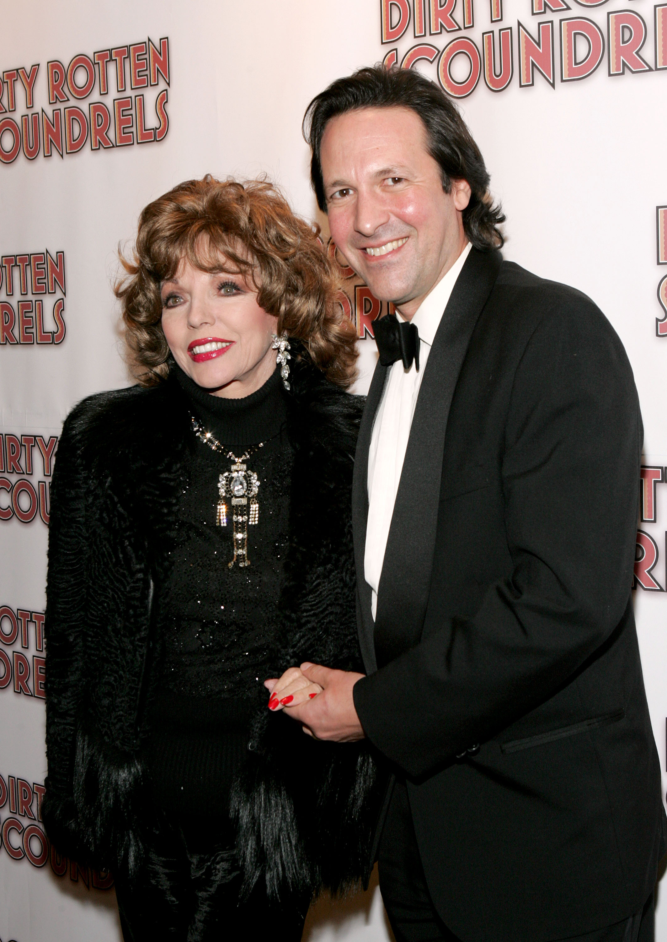 Joan Collins, wearing red nail polish, with her husband Percy Gibson on March 3, 2005, in New York City | Source: Getty Images