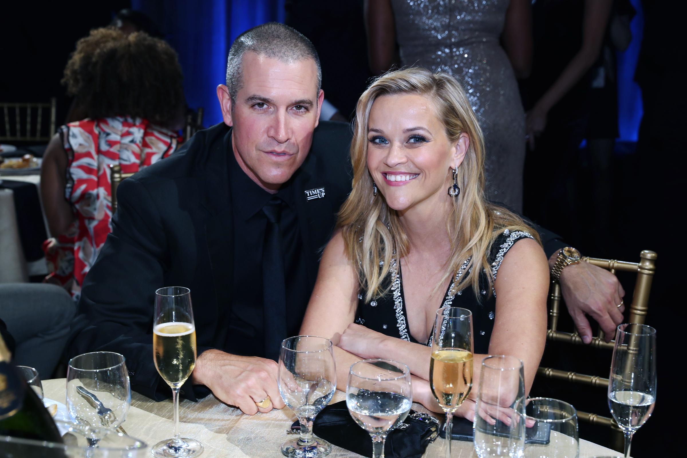 Jim Toth and Witherspoon are seated at a table enjoying drinks as they attend the 23rd Annual Critics' Choice Awards at Barker Hangar on January 11, 2018, in Santa Monica, California.