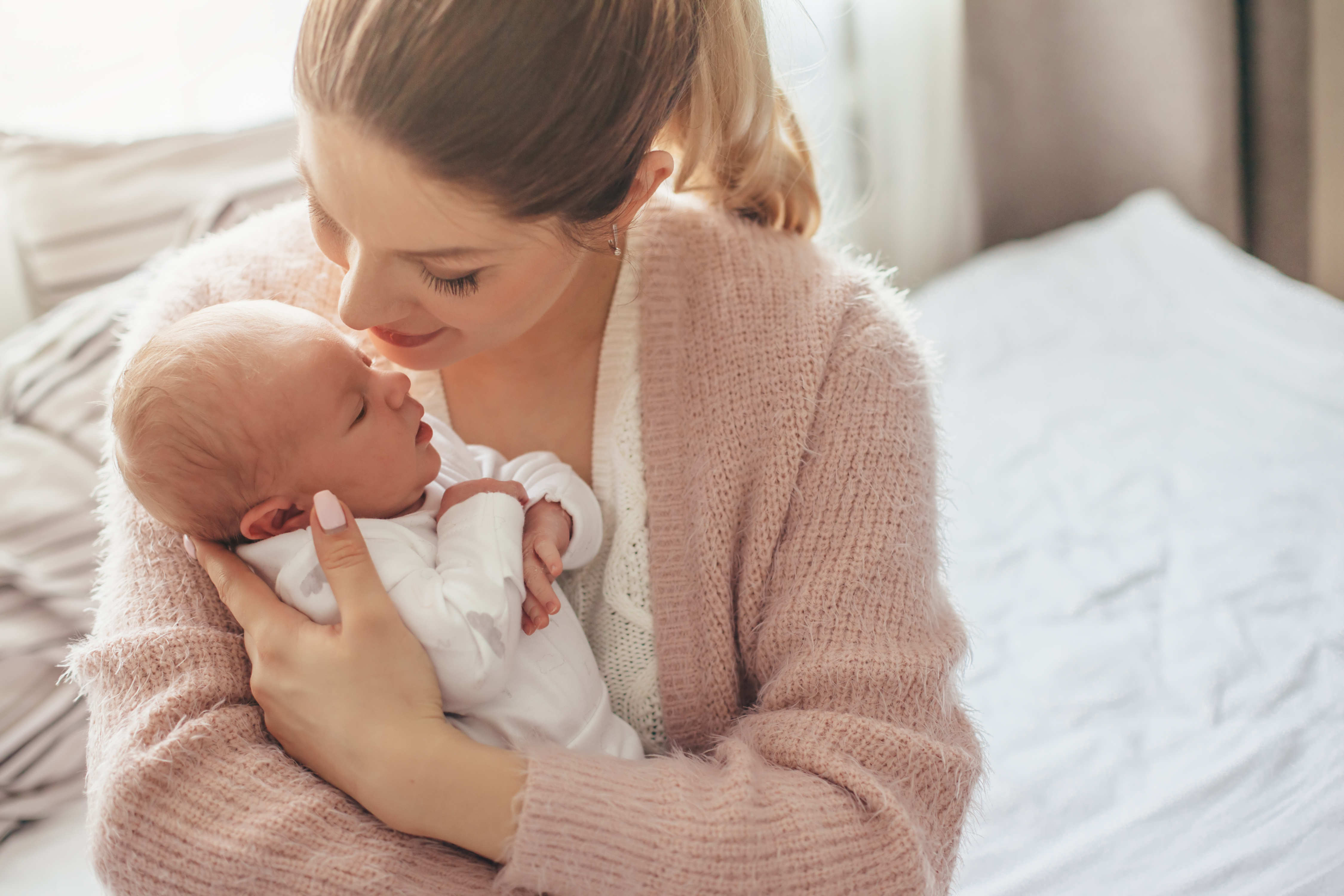 Mother holding her newborn baby | Source: Shutterstock