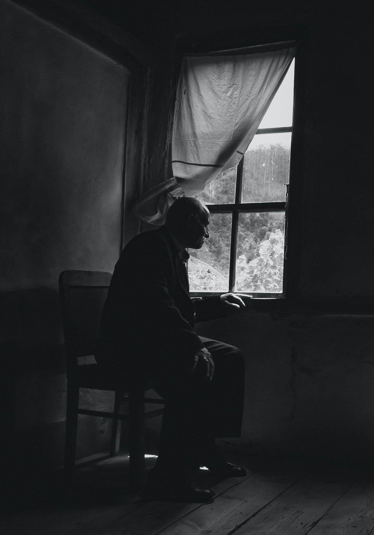 Hombre mayor sentado frente a una ventana. | Foto: Pexels