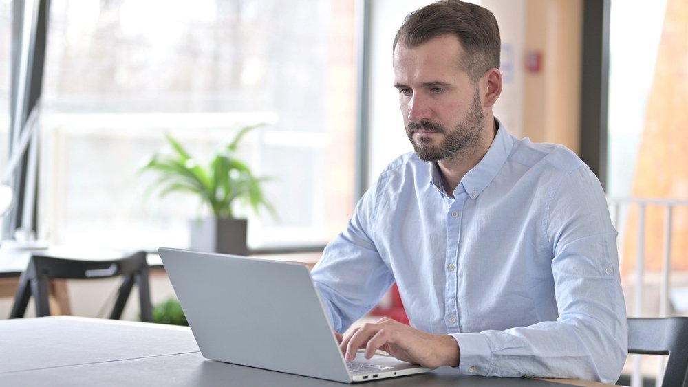 Man looking serious while on a laptop | Photo: Shutterstock/Stockbakery