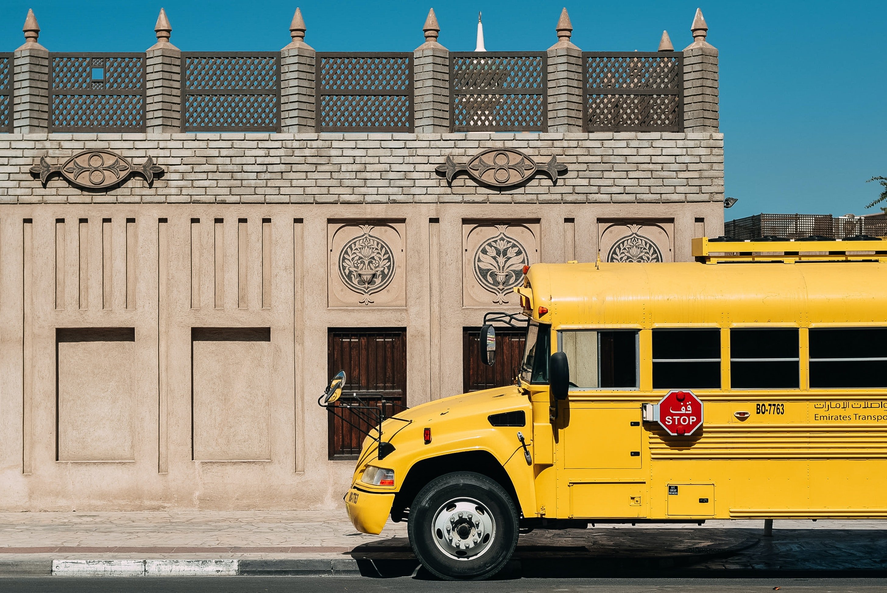 Un autobús escolar esperando frente a una escuela. | Foto: Pexels
