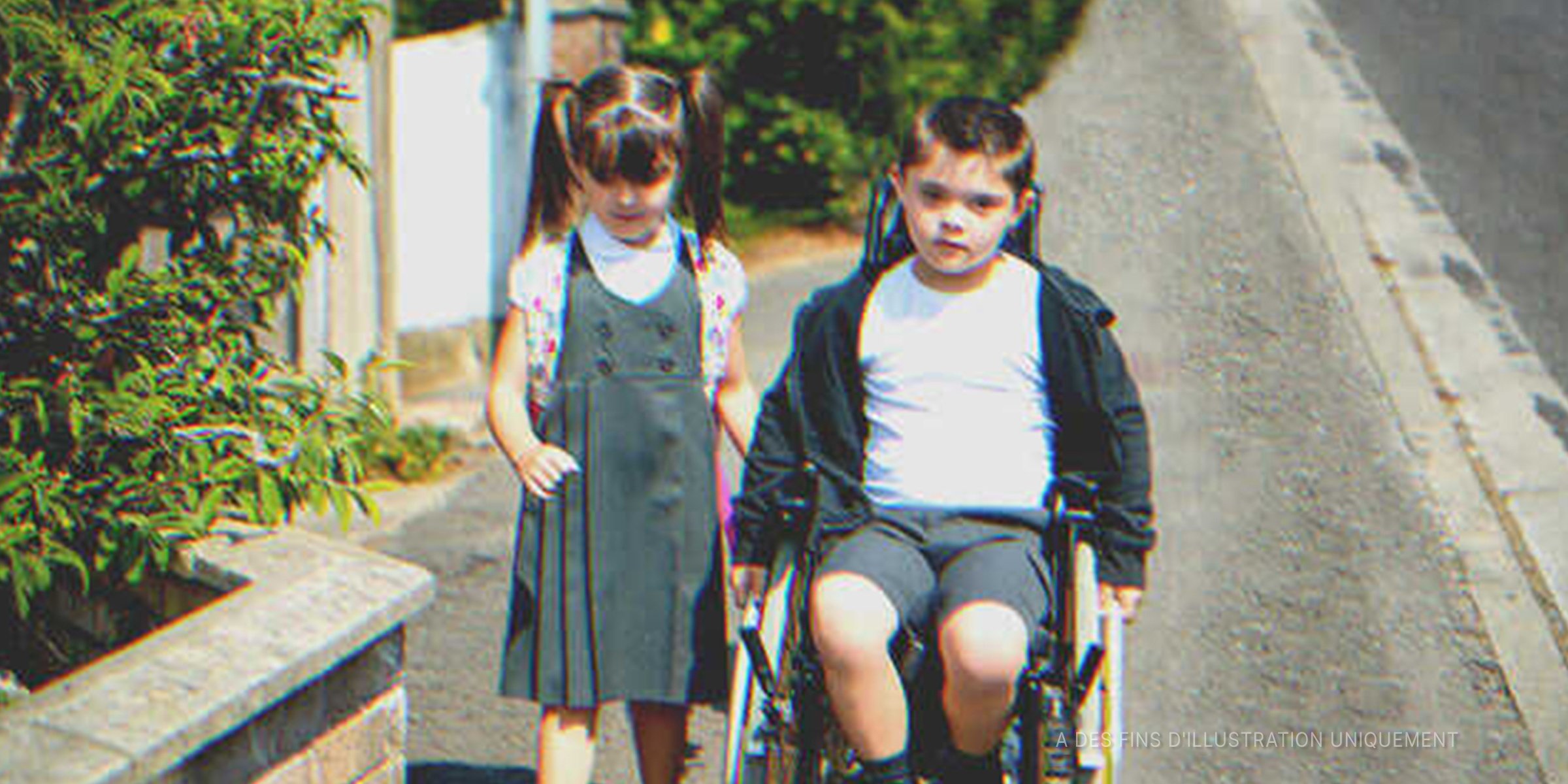 Un petit garçon en fauteuil roulant à côté d'une petite fille | Source : Shutterstock