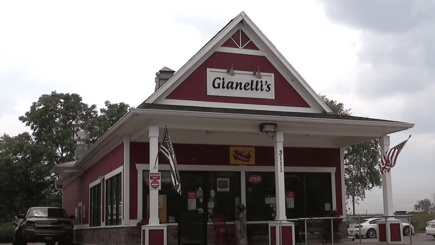 Two American flags hang outside of a restaurant and have caused controversy between the village council and the business owner | Photo: Youtube/FOX 32 Chicago