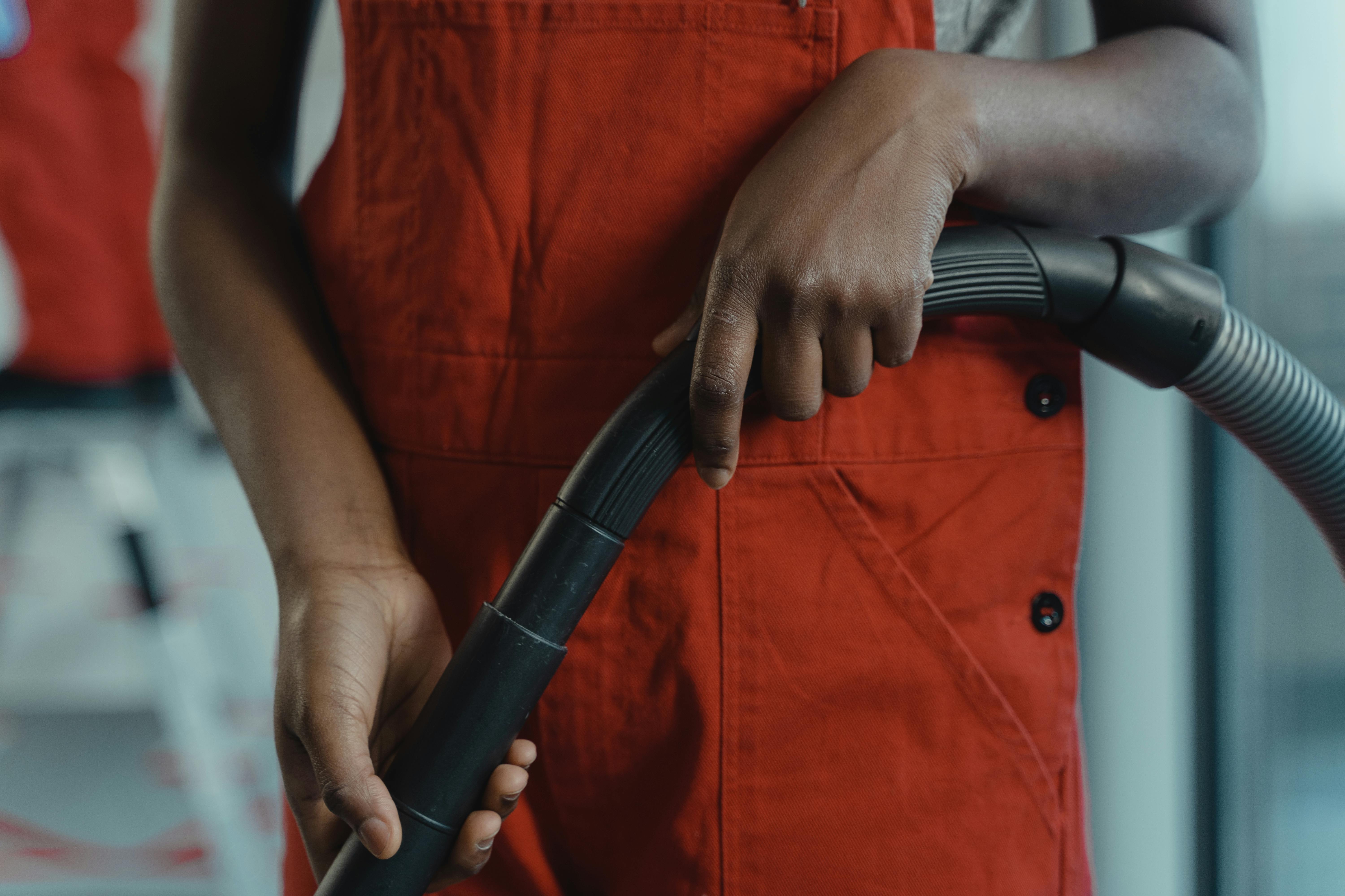 A worker operating a vacuum cleaner | Source: Pexels