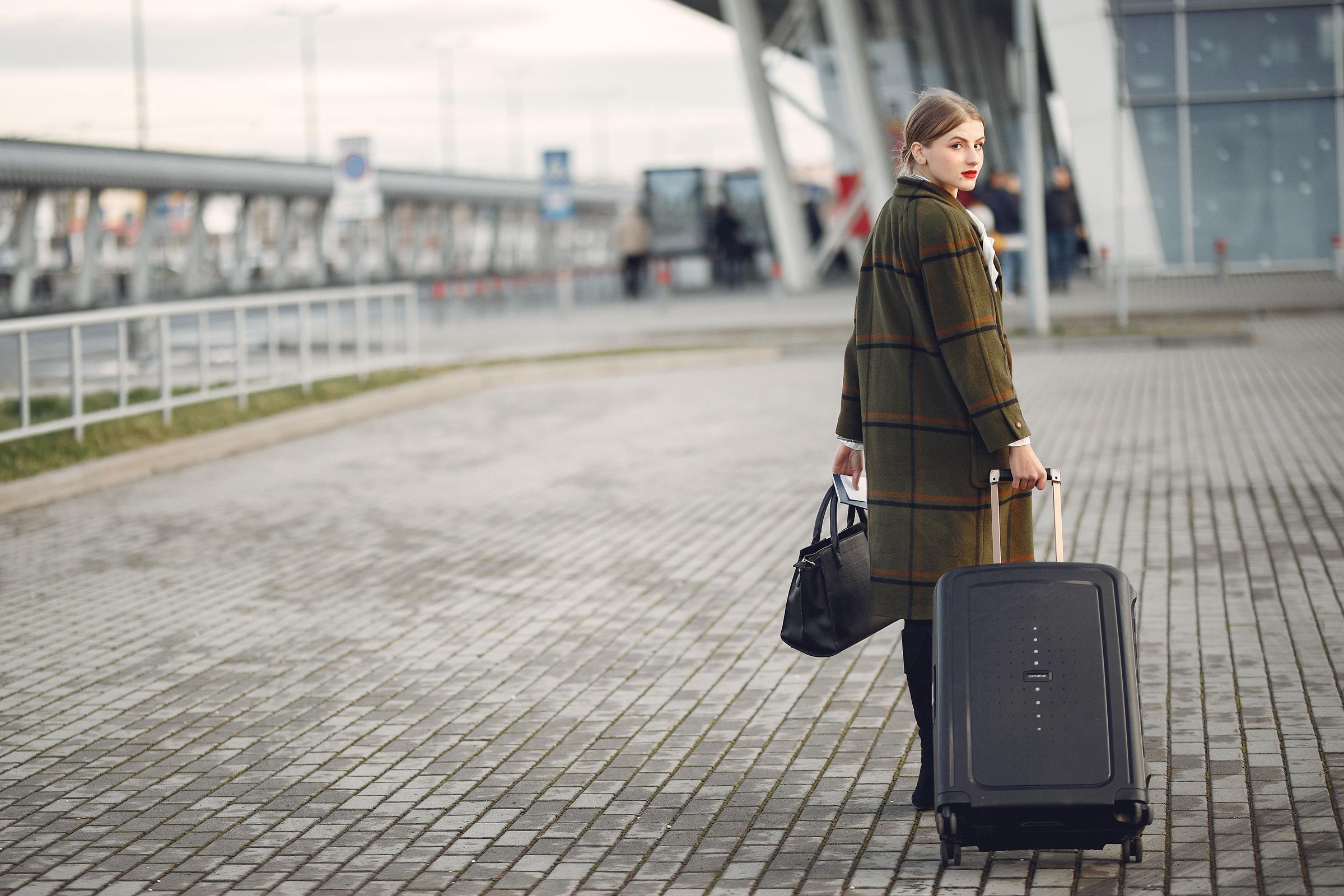 A woman walking with her luggage | Source: Pexels