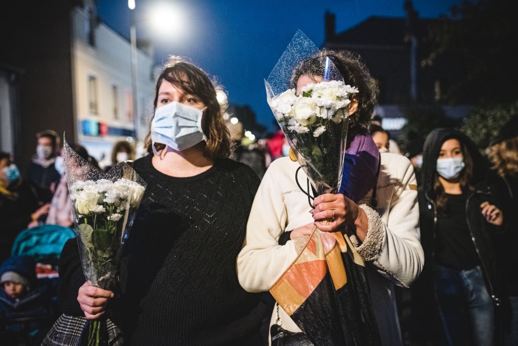 Deux femmes portant des bouquets de fleurs. | Photo : Getty Images