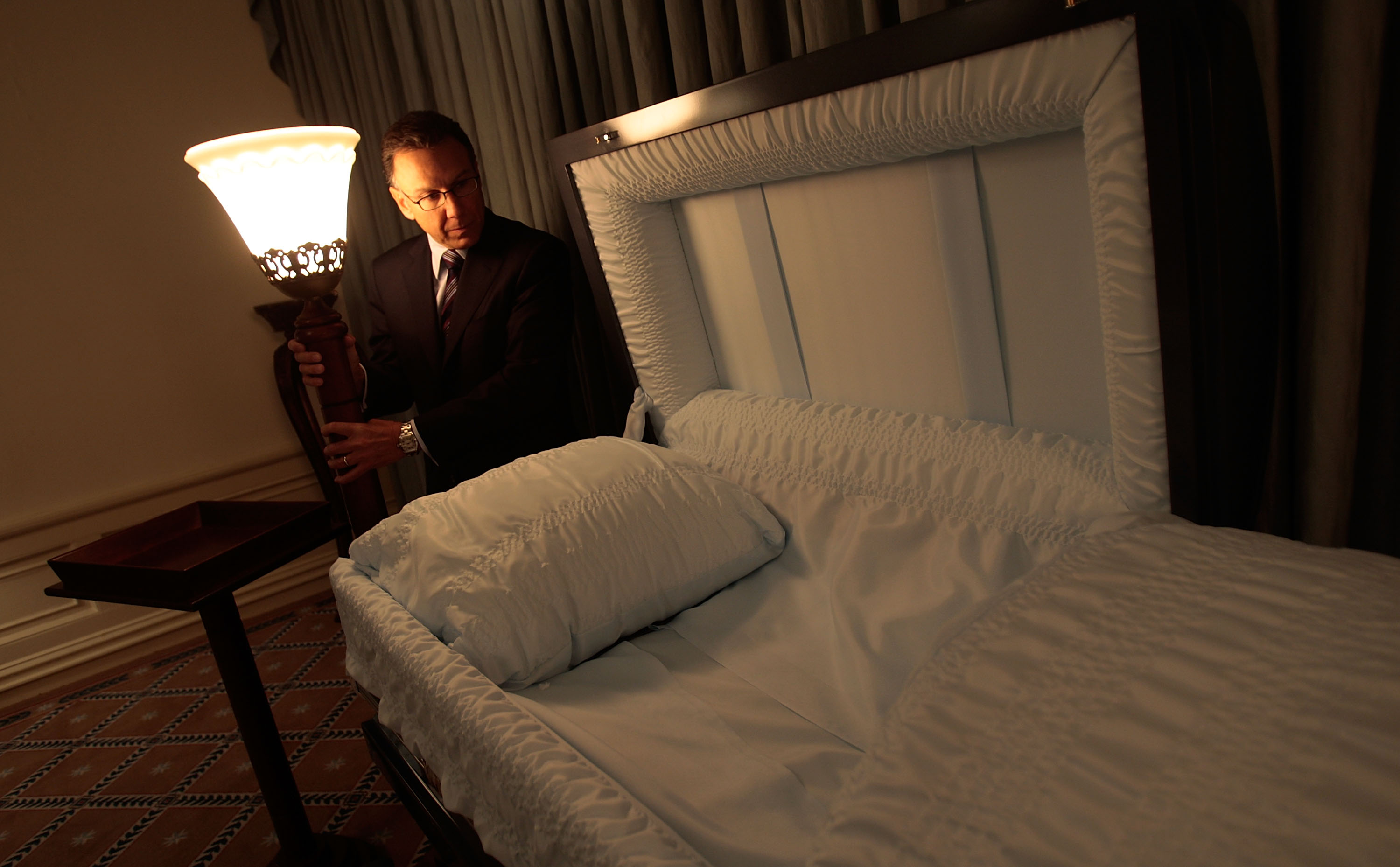 Peter DeLuca looks over a casket in his funeral parlor on November 20, 2008, in New York City. | Source: Getty Images